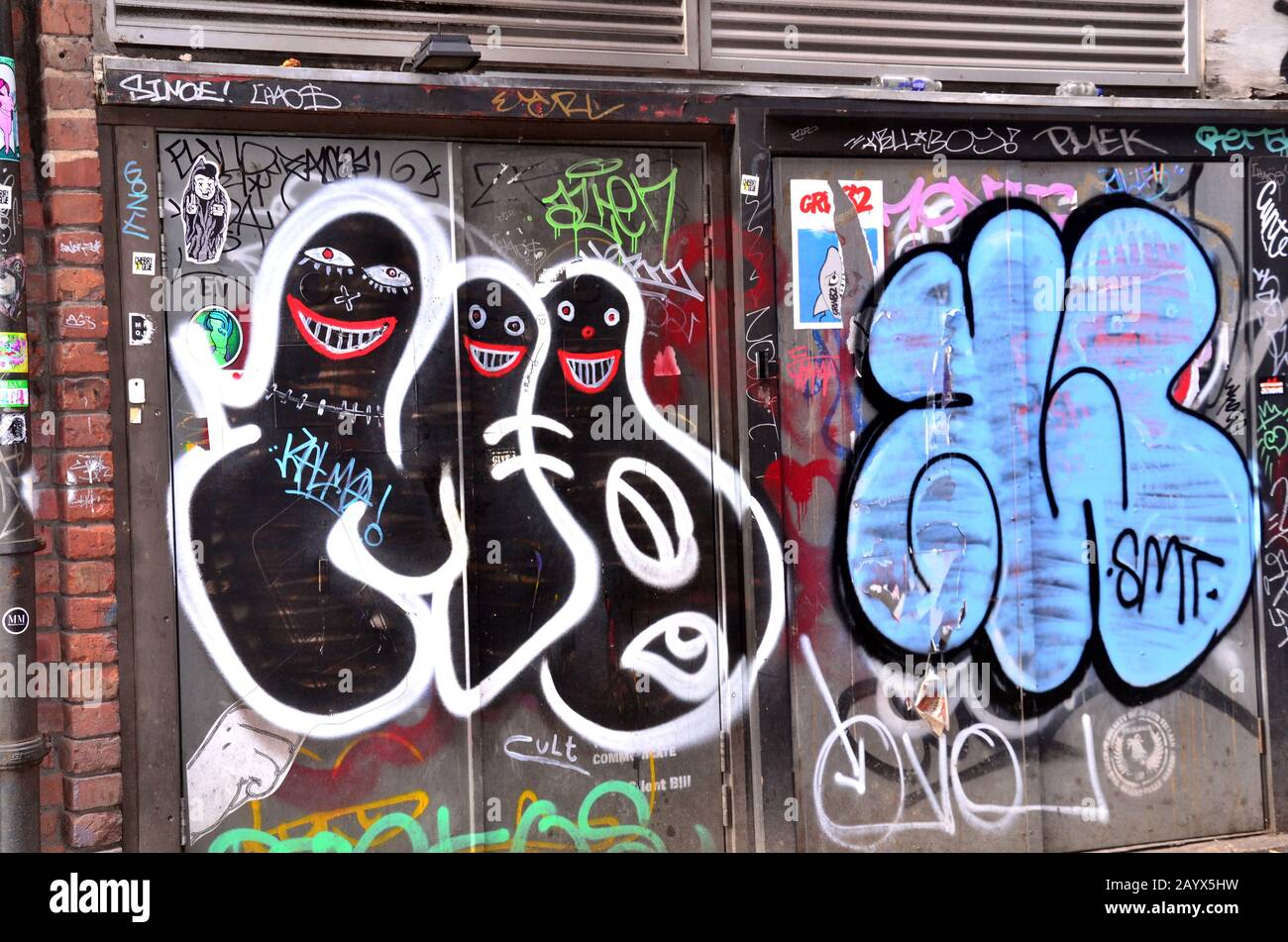 Opere d'arte e graffiti, che alcuni chiamerebbero vandalismo, decorano le strade nel quartiere settentrionale della città interna di Manchester, Regno Unito Foto Stock