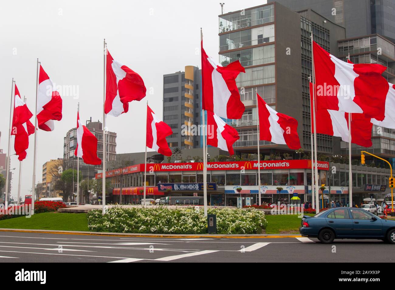 Street scene a Miraflores, Lima, Perù con una piazza con bandiere peruviane e un McDonalds 'fast food ristorante. Foto Stock