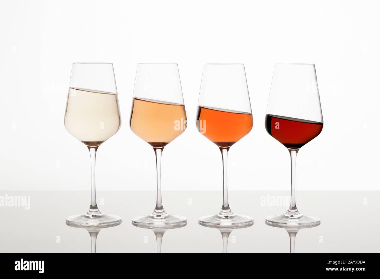 quattro bicchieri da vino con vino bianco, rosa e rosso ad angolo acuto Foto Stock