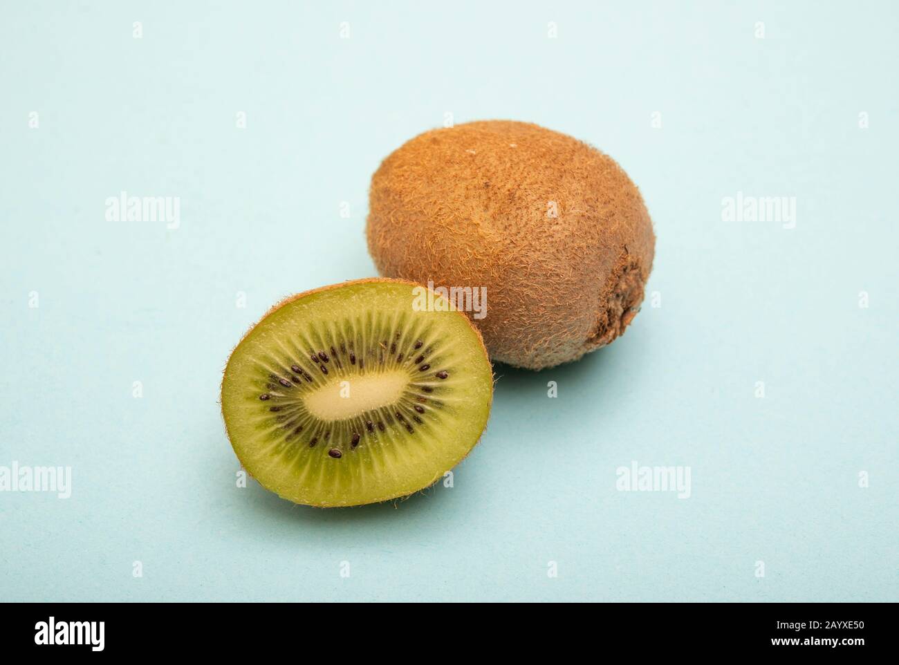 Frutta Kiwi isolata a metà tagliata su sfondo blu Foto Stock