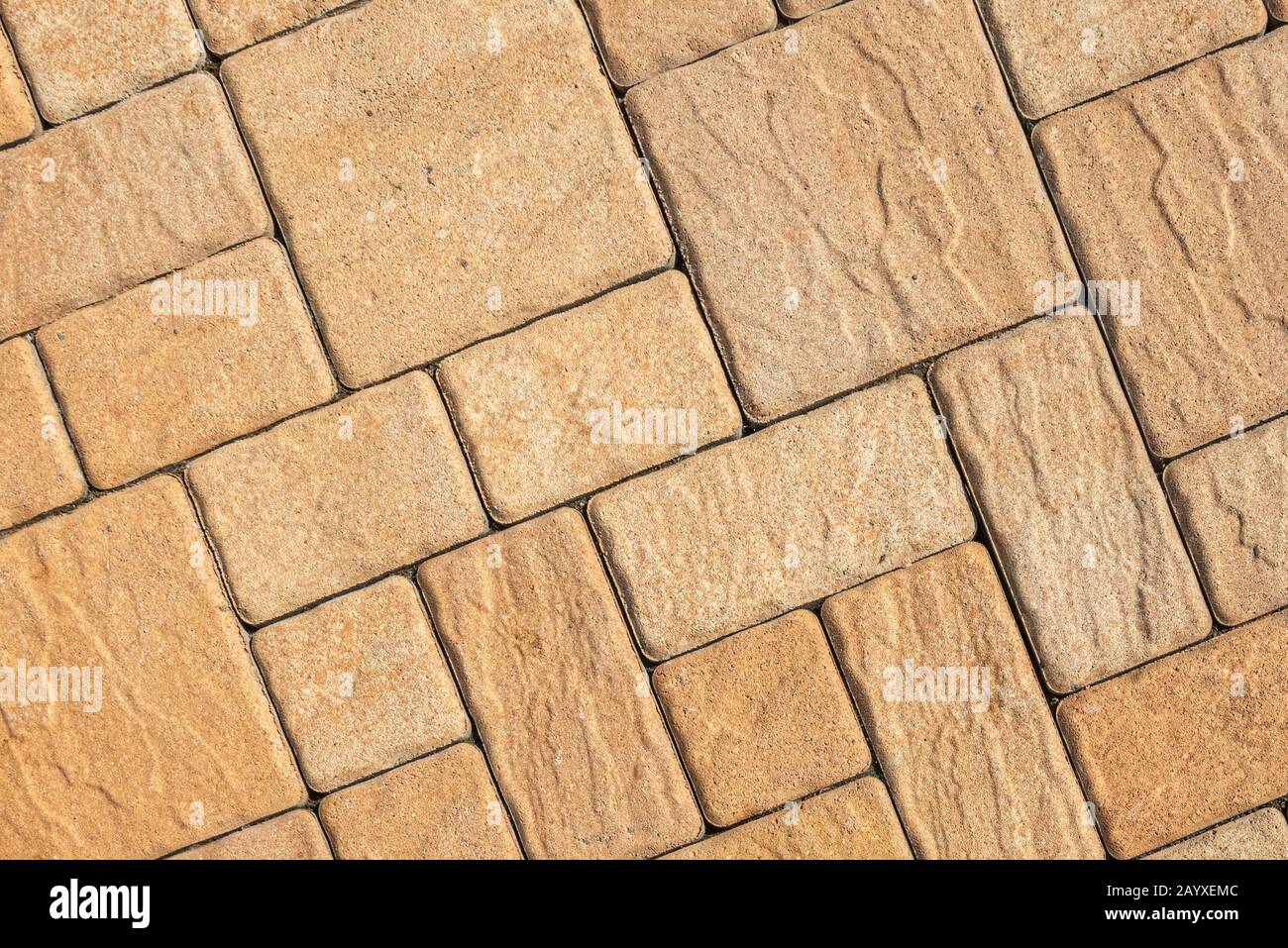 Fondo stradale molto dettagliato con motivo geometrico diagonale composto da vari blocchi quadrati con superficie ruvida testurizzata colorata in beige Foto Stock