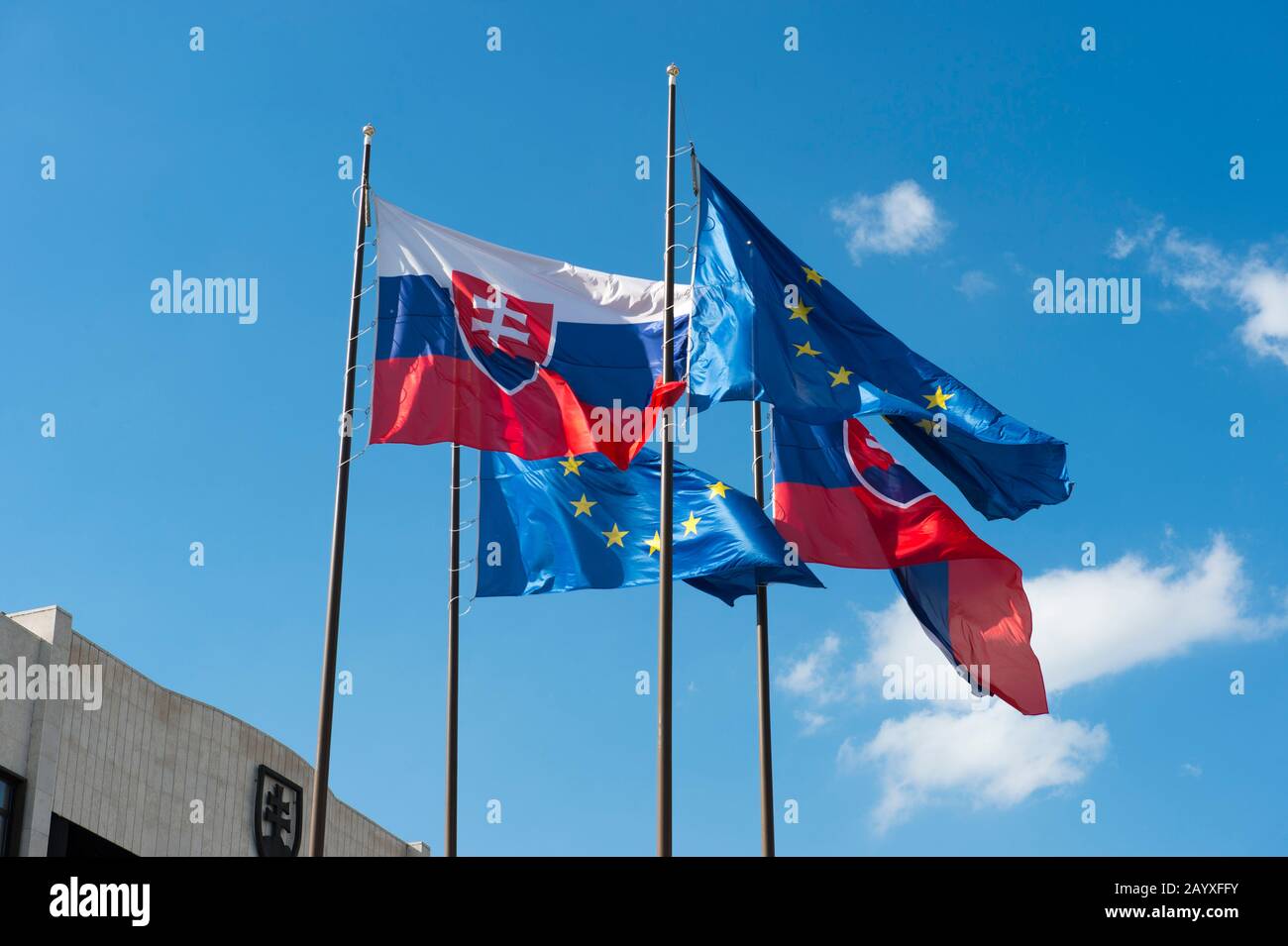 Bandiere nazionali e dell'Unione europea di fronte all'edificio del Parlamento a Bratislava, la capitale della Slovacchia. Foto Stock