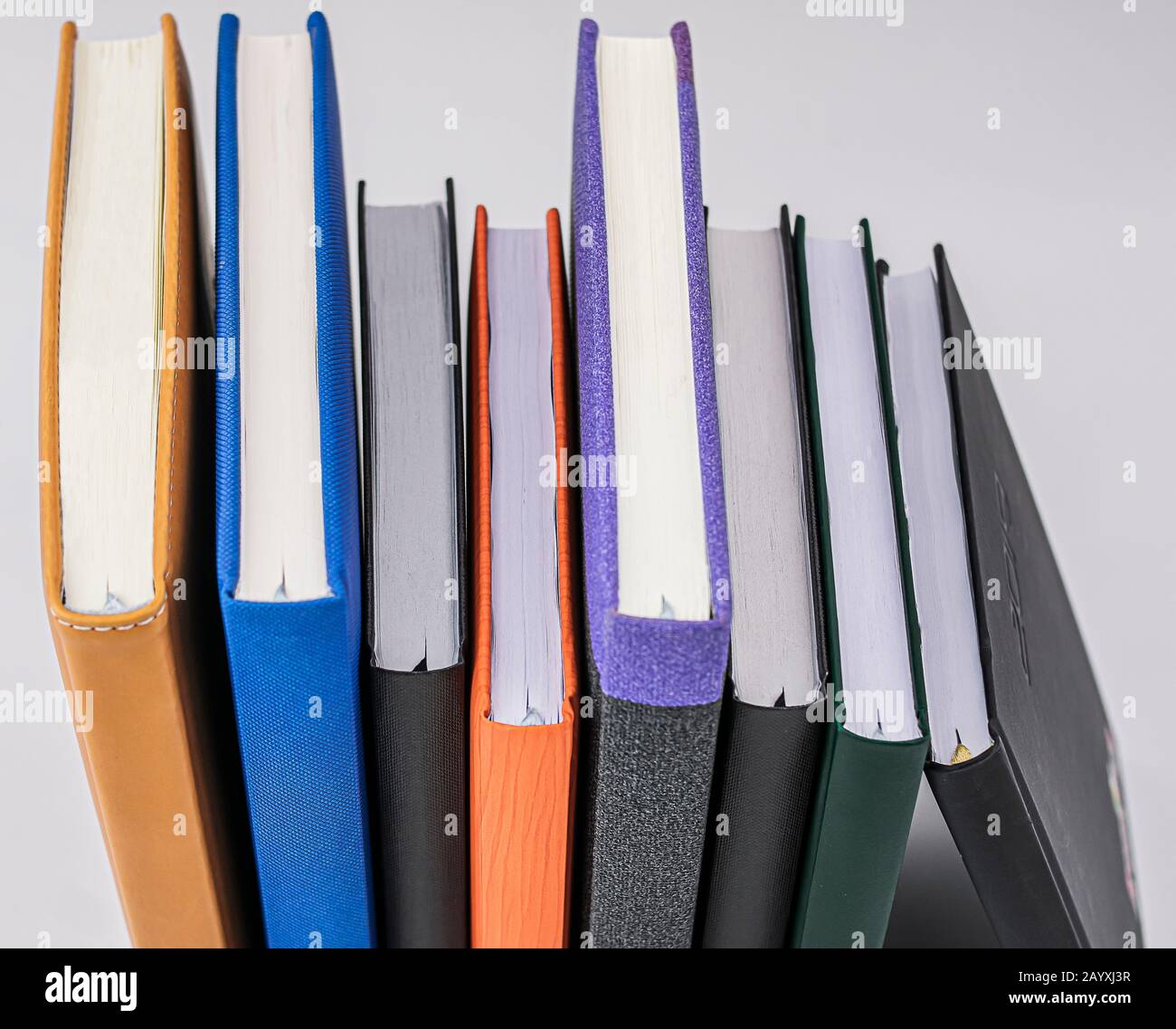 diversi libri di colori diversi visti dalla prospettiva zenitale su sfondo bianco Foto Stock