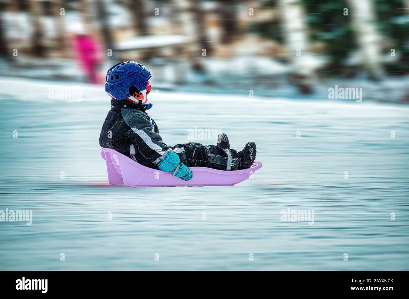 Ragazzo giovane a tutta velocità con il suo corridore di neve Foto Stock