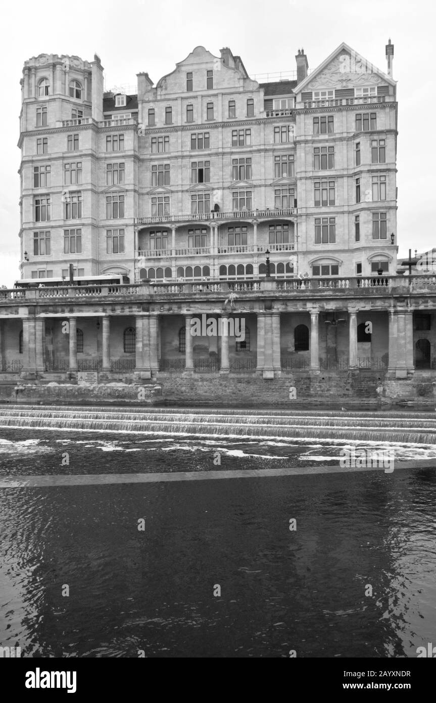 Una vista sul fiume Avon con Pulteney weir in primo piano con l'ex Empire Hotel dietro Foto Stock