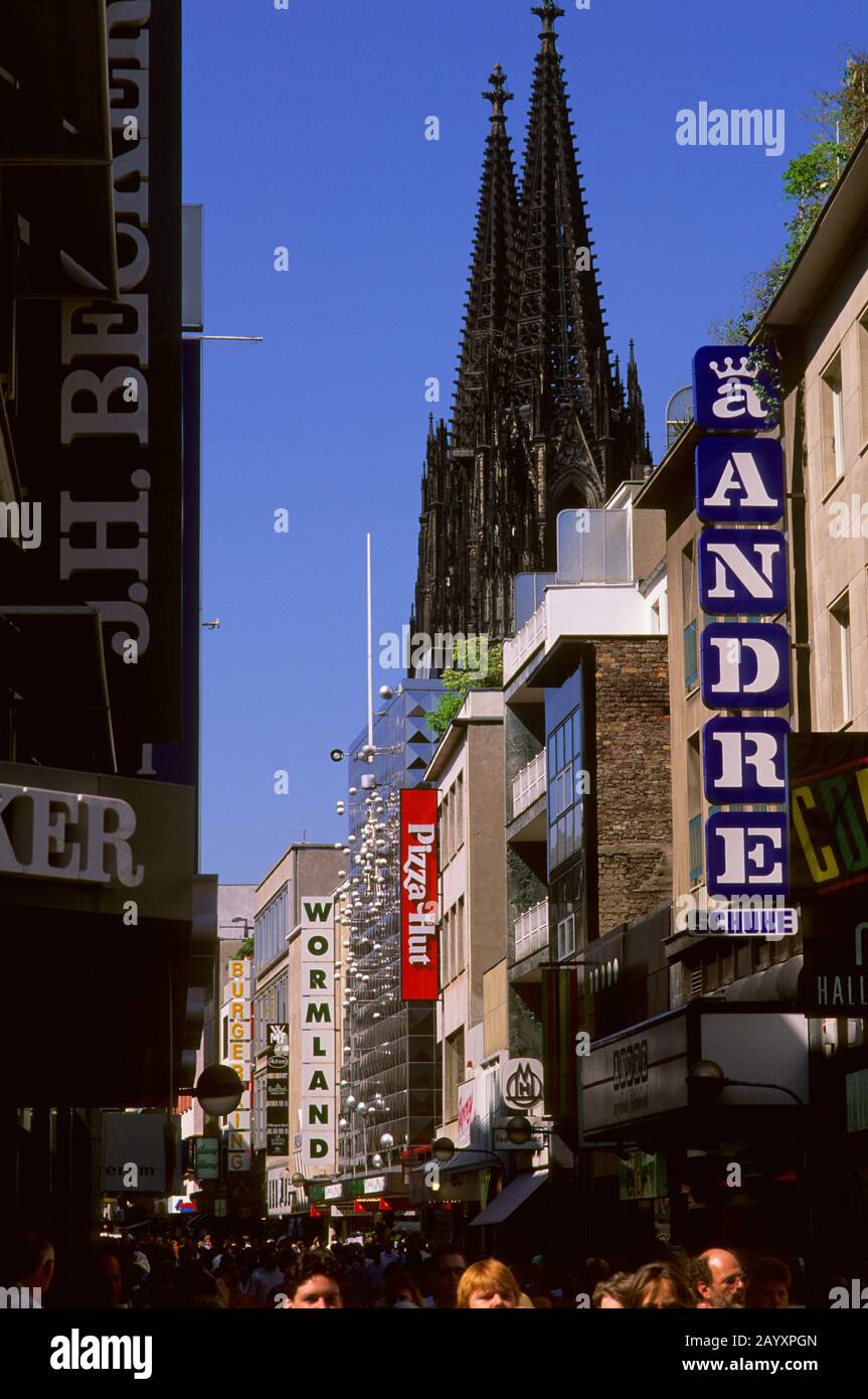Una scena di strada della strada pedonale Hohe Strasse a Colonia in Nordrhein-Westfalen, Germania, con la cattedrale di Colonia sullo sfondo. Foto Stock