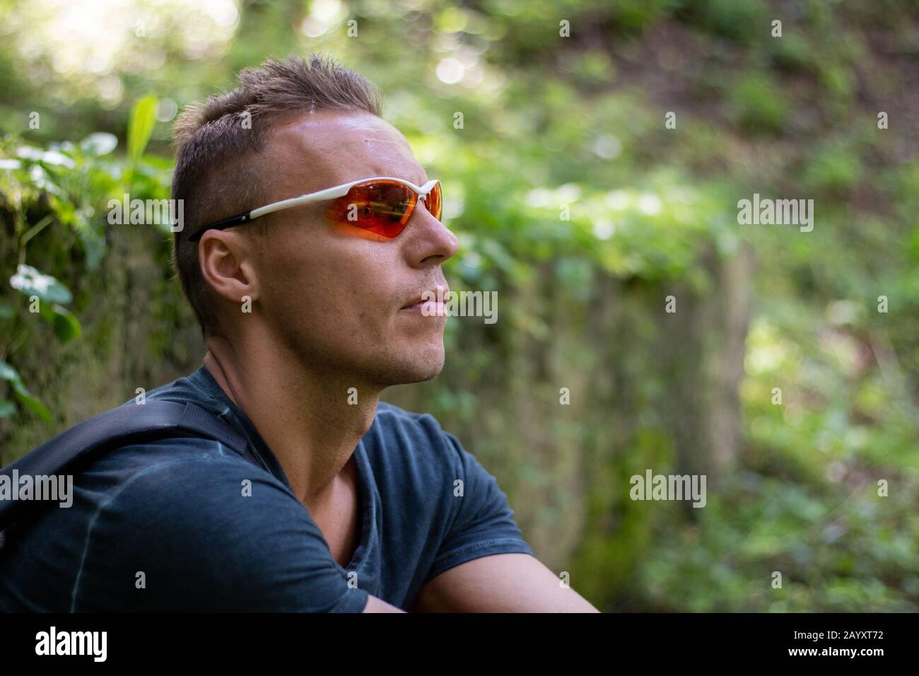 Un uomo atletico nei boschi, rilassante al tramonto. Foto Stock