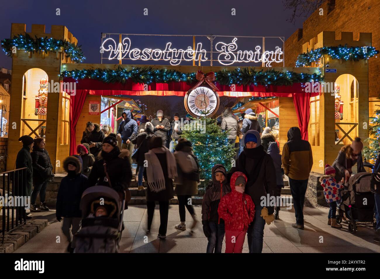 Varsavia, Polonia - 27 dicembre 2019: Persone che entrano e lasciano il mercatino di Natale di notte, luogo per acquistare merci tradizionali nella città vecchia della capitale Foto Stock