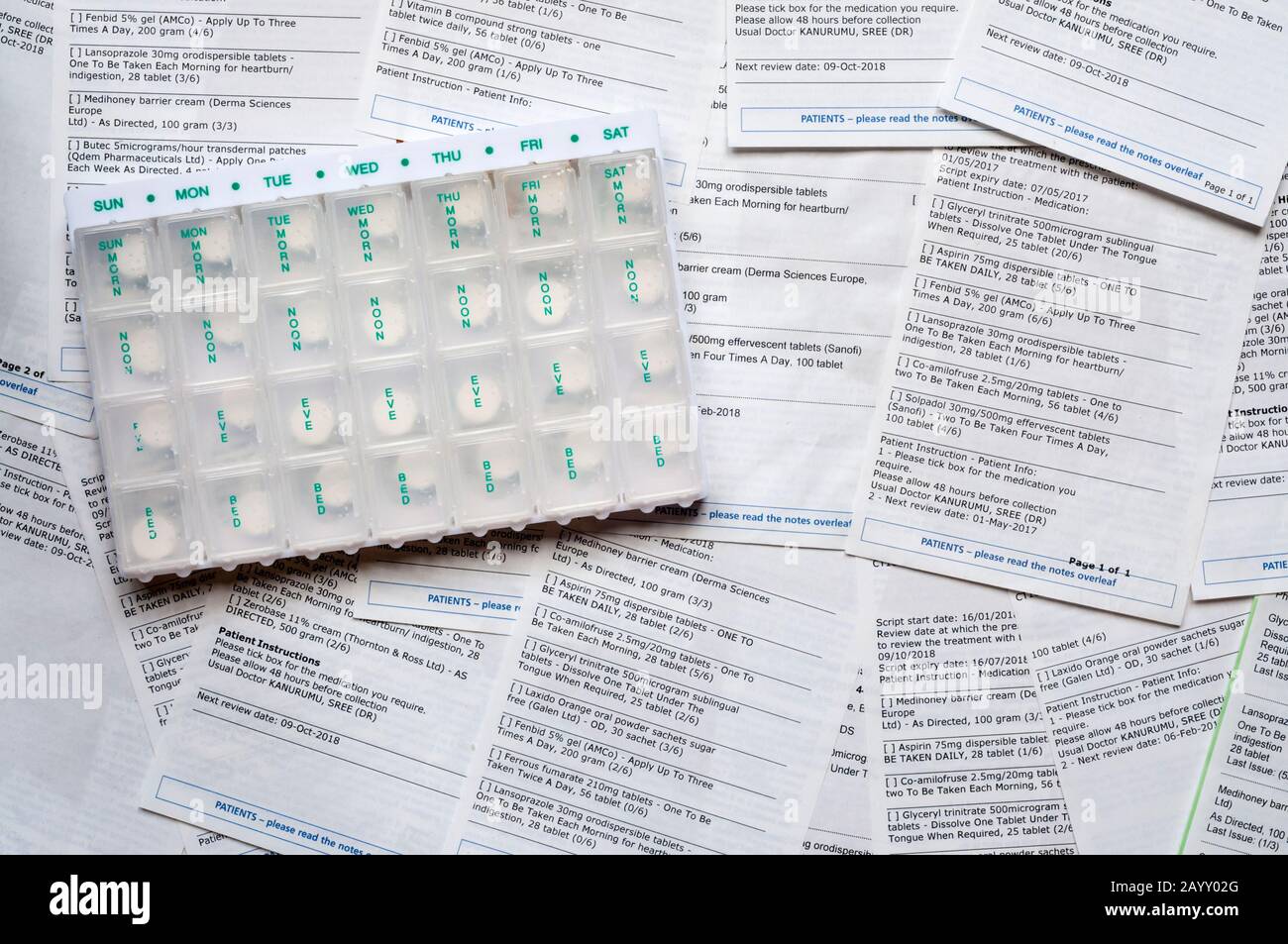 Una selezione di richieste di prescrizione medica ripetuta da parte di un medico, con un organizzatore di pillole. NB i dati sono stati anonimizzati. Foto Stock