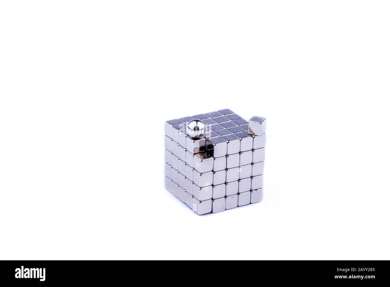 Divertente pensare fuori dalla scatola in cubi di magnete giocattolo e palle isolato su uno sfondo bianco puro Foto Stock