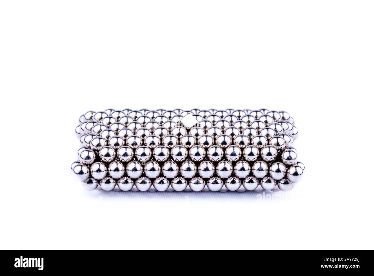 Divertente pensare fuori dalla scatola in cubi di magnete giocattolo e palle isolato su uno sfondo bianco puro come un cuscino con un diamante sulla parte superiore Foto Stock
