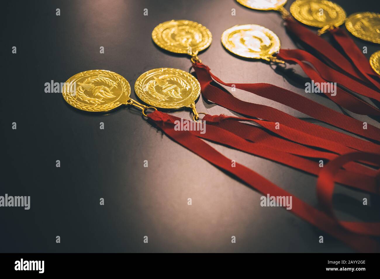 Medaglie d'oro olimpiche su un tavolo nero per premiare i vincitori. Foto Stock