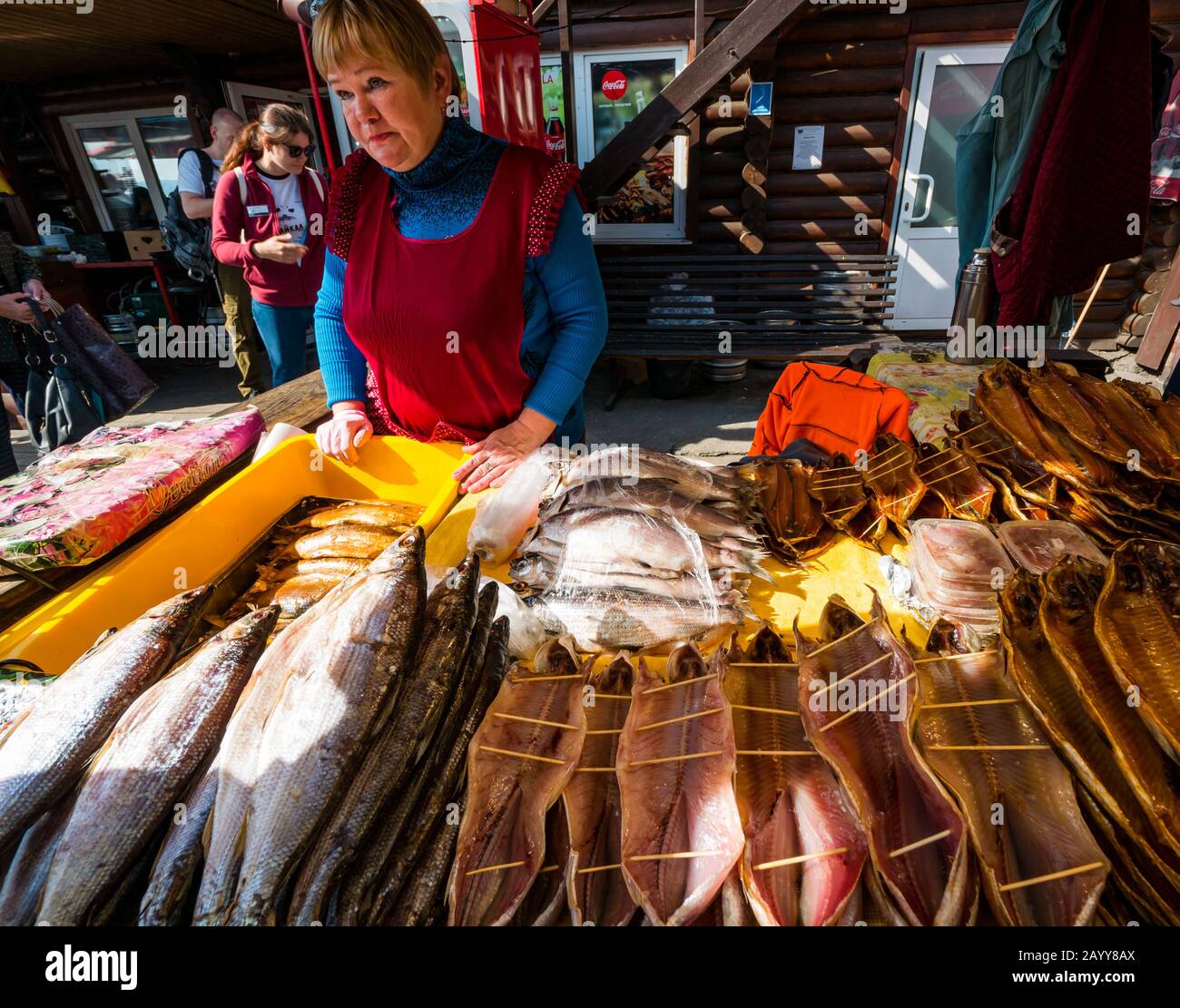 Donna che vende pesce secco e affumicato in vendita presso lo stallo del mercato, Listvyanka, Irkutsk Region, Siberia, Russia Foto Stock