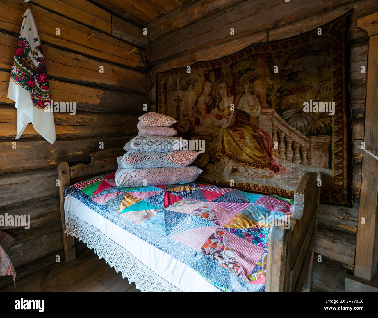 Interno casetta con letto e trapunta patchwork raffigurante stile di vita tradizionale, Museo Taltsy di architettura di legno, Regione Irkutsk, Siberia Foto Stock