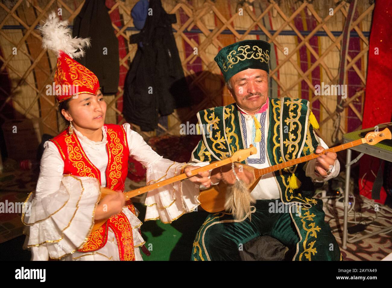 Padre e figlia suonano canzoni kazake tradizionali con dombras kazakh (strumento a corda) in un ger vicino alla città di Ulgii (Ölgii) nella Bayan-U. Foto Stock