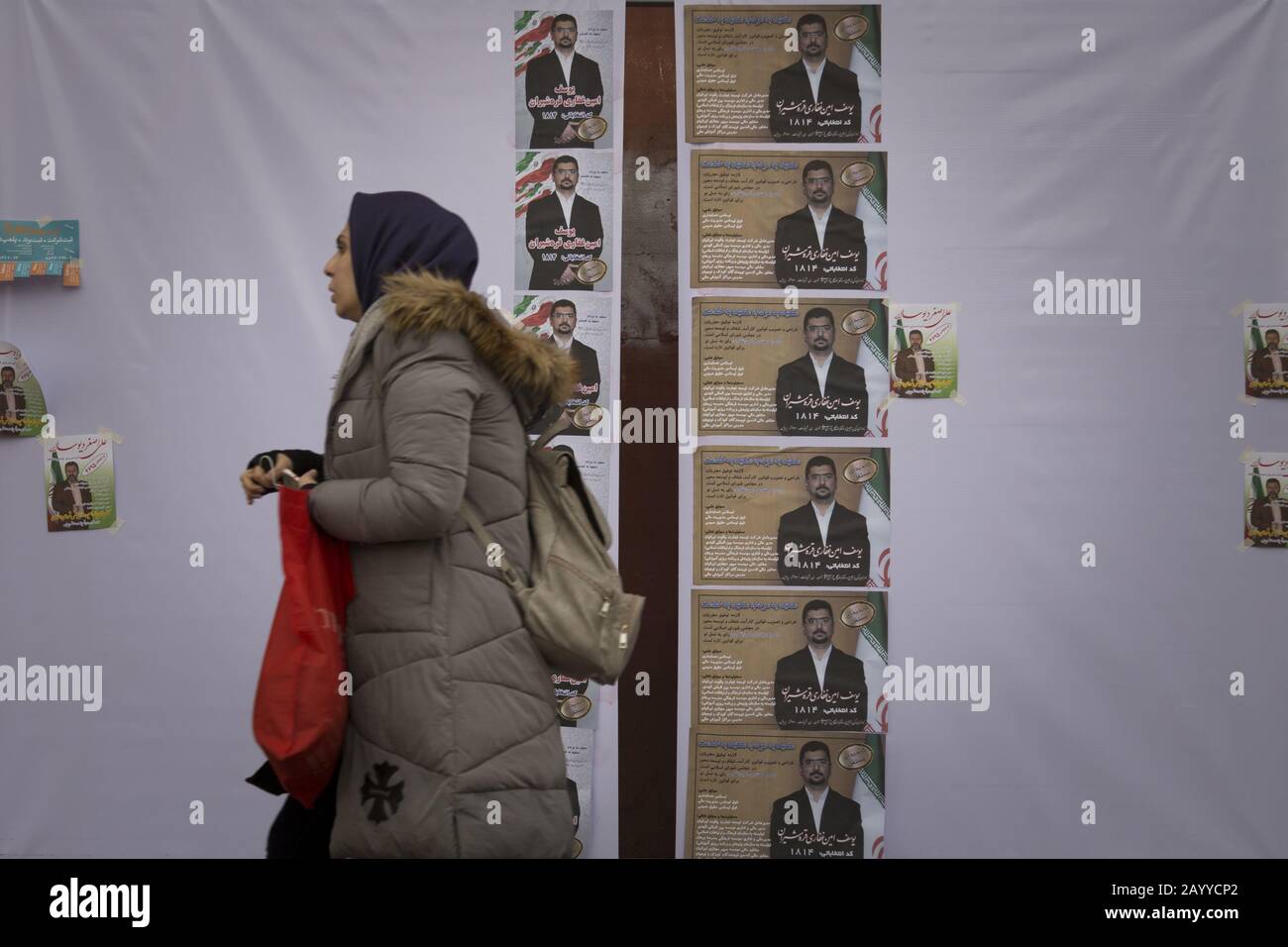 Teheran, Iran. 17th Feb, 2020. Gli iraniani camminano oltre i manifesti elettorali in una strada di Teheran, Iran. Le elezioni parlamentari iraniane del 21 febbraio sono viste come una prova della popolarità del blocco relativamente moderato e pro-riforma del presidente Rouhani. Il suo governo, tuttavia, ha lottato per la maggior parte per mantenere le promesse di campagna per migliorare la vita delle persone mentre l'economia dell'Iran si fa carico delle sanzioni statunitensi. Credit: Zuma Press, Inc./Alamy Live News Foto Stock