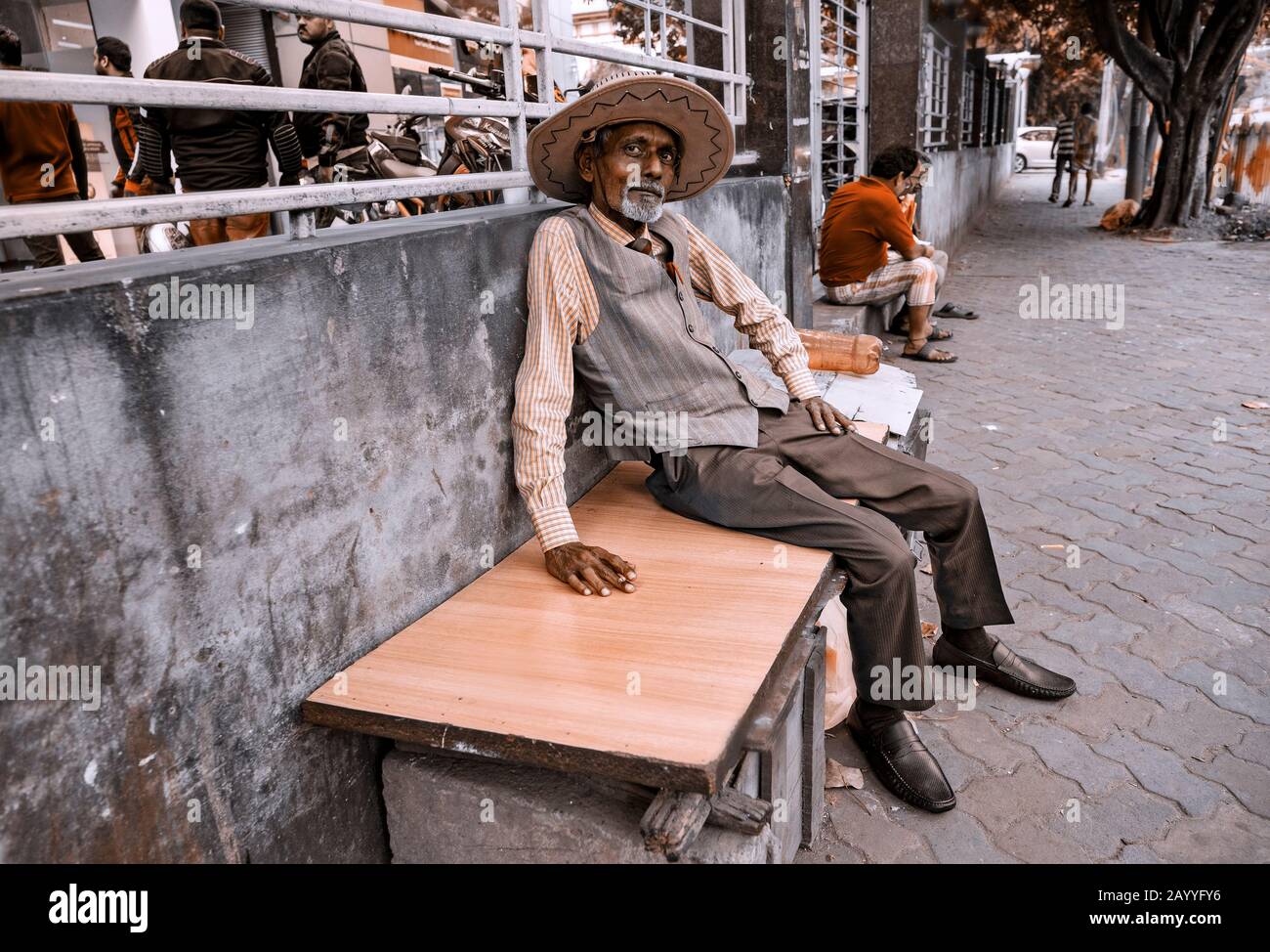 Uomo con una sigaretta rilassante su una panchina a Calcutta, India Foto Stock
