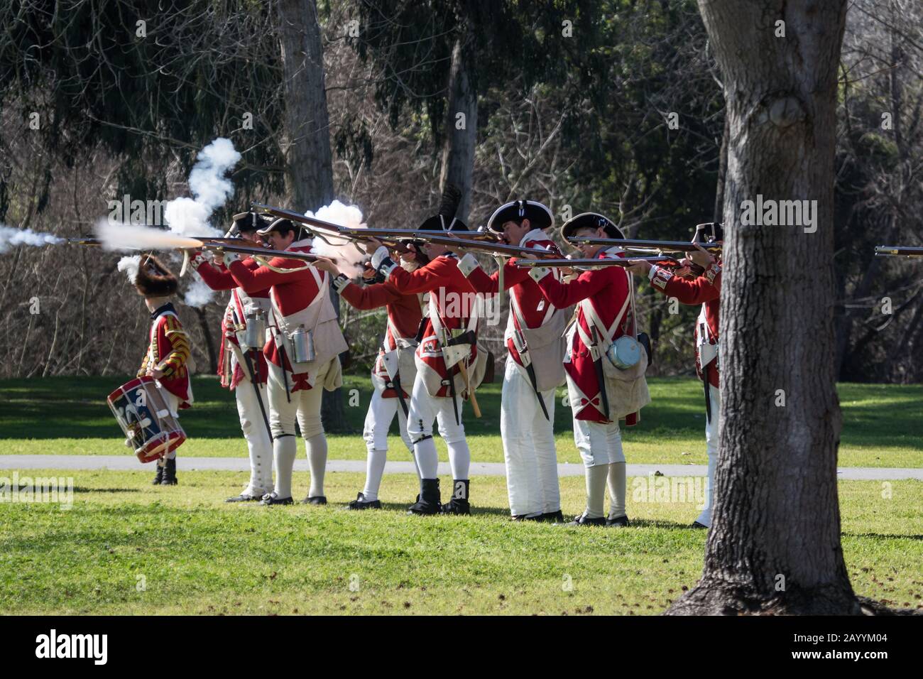 Soldati britannici redcoat che sparano i moschetti durante una rievocazione della rivoluzione americana nel 'Huntington Central Park' Huntington Beach California USA Foto Stock