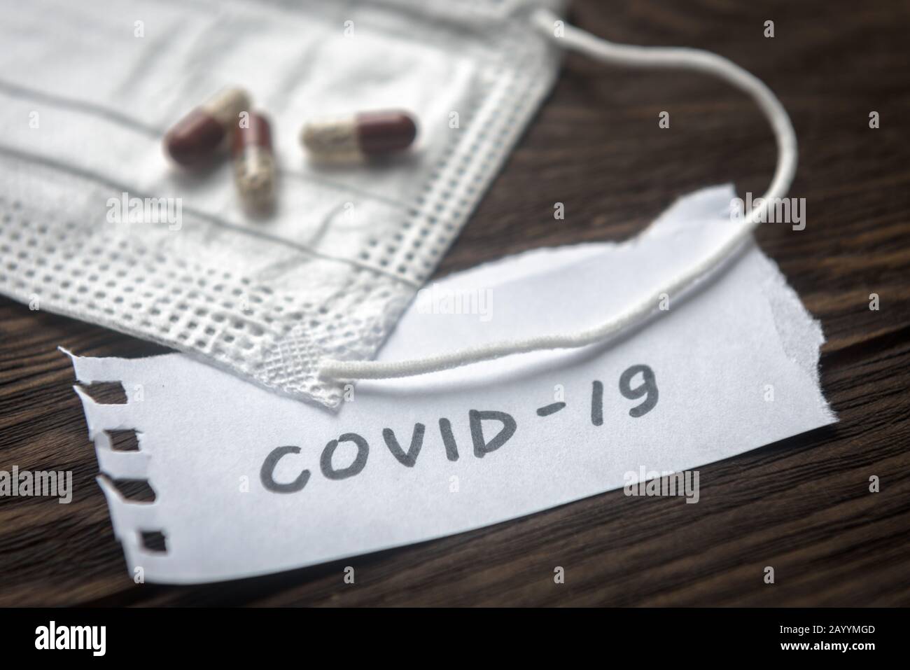 Concetto di coronavirus. Nota COVID-19, maschera medica Protettiva e capsule di pillola per il trattamento del coronavirus. Focolaio del virus corona nuovo. Epidemia di Wu Foto Stock