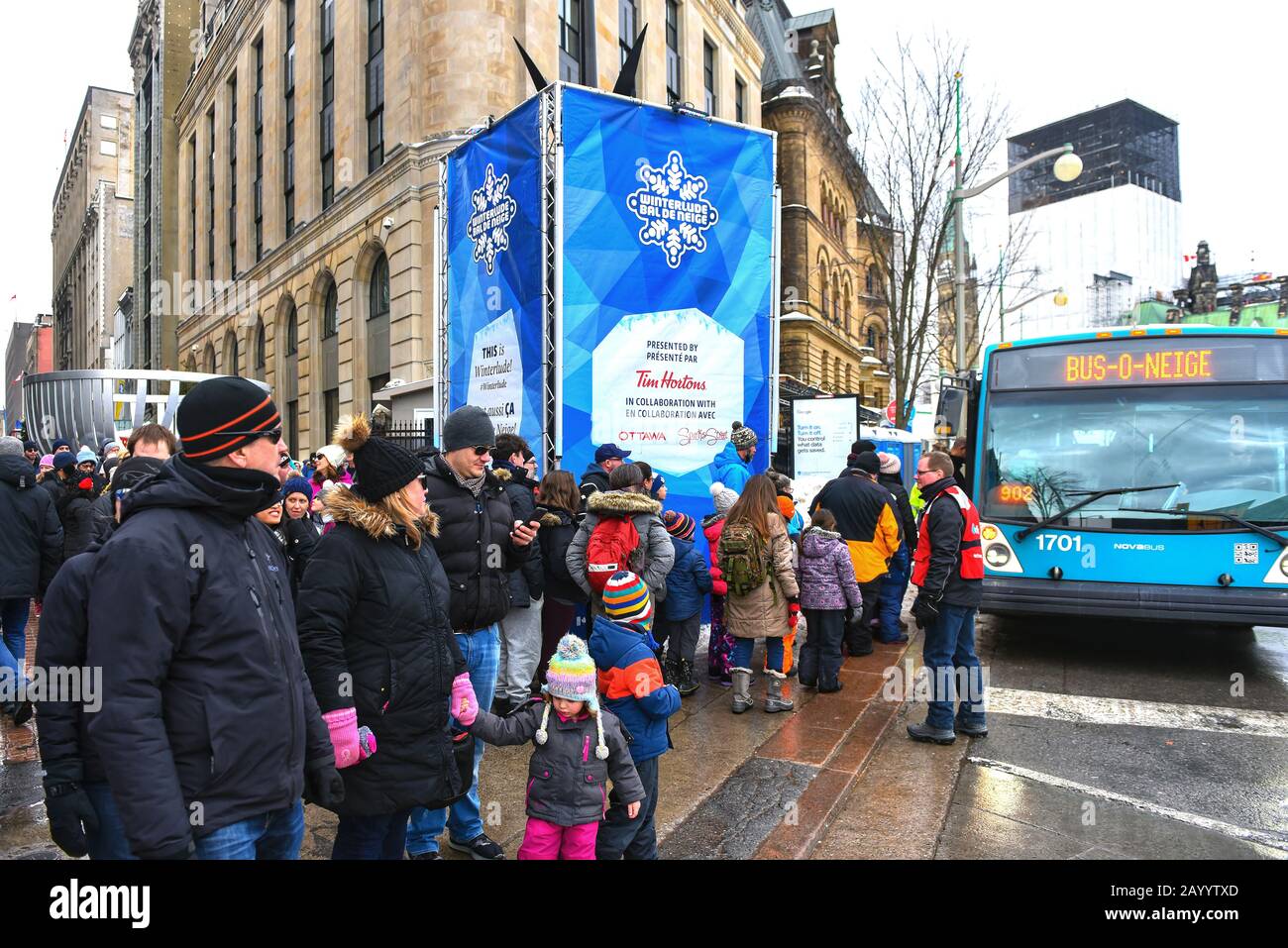 Ottawa, Canada - 16 febbraio 2020: La gente aspetta in linea su Sparks Street per lo Snow Bus per portarli in un luogo diverso dell'annuale Winterlude F. Foto Stock