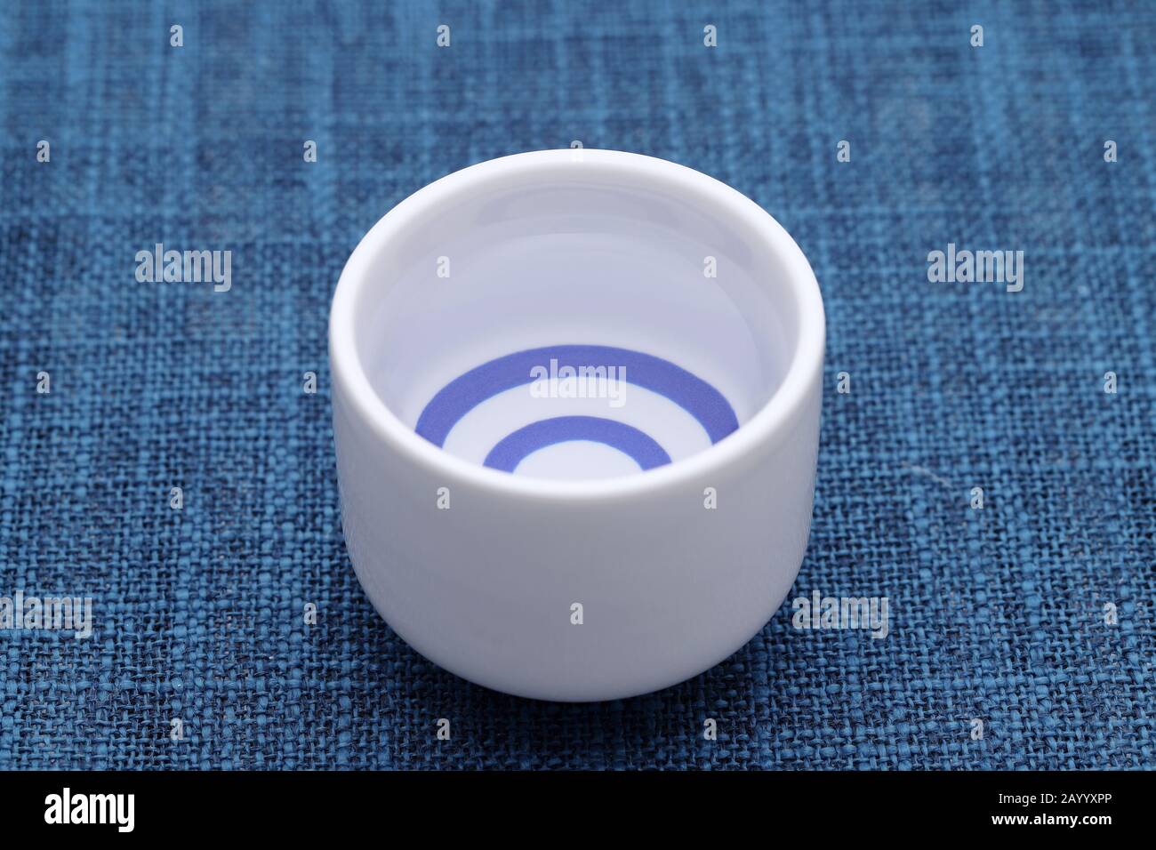 Sake giapponese in tradizionale tazza di ocoko ceramica su tavolo di legno Foto Stock