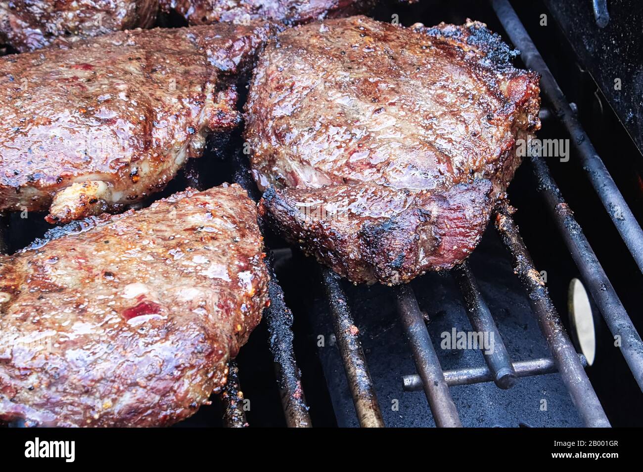 Primo piano di bistecche barbecue che cucinano su una griglia. Foto Stock