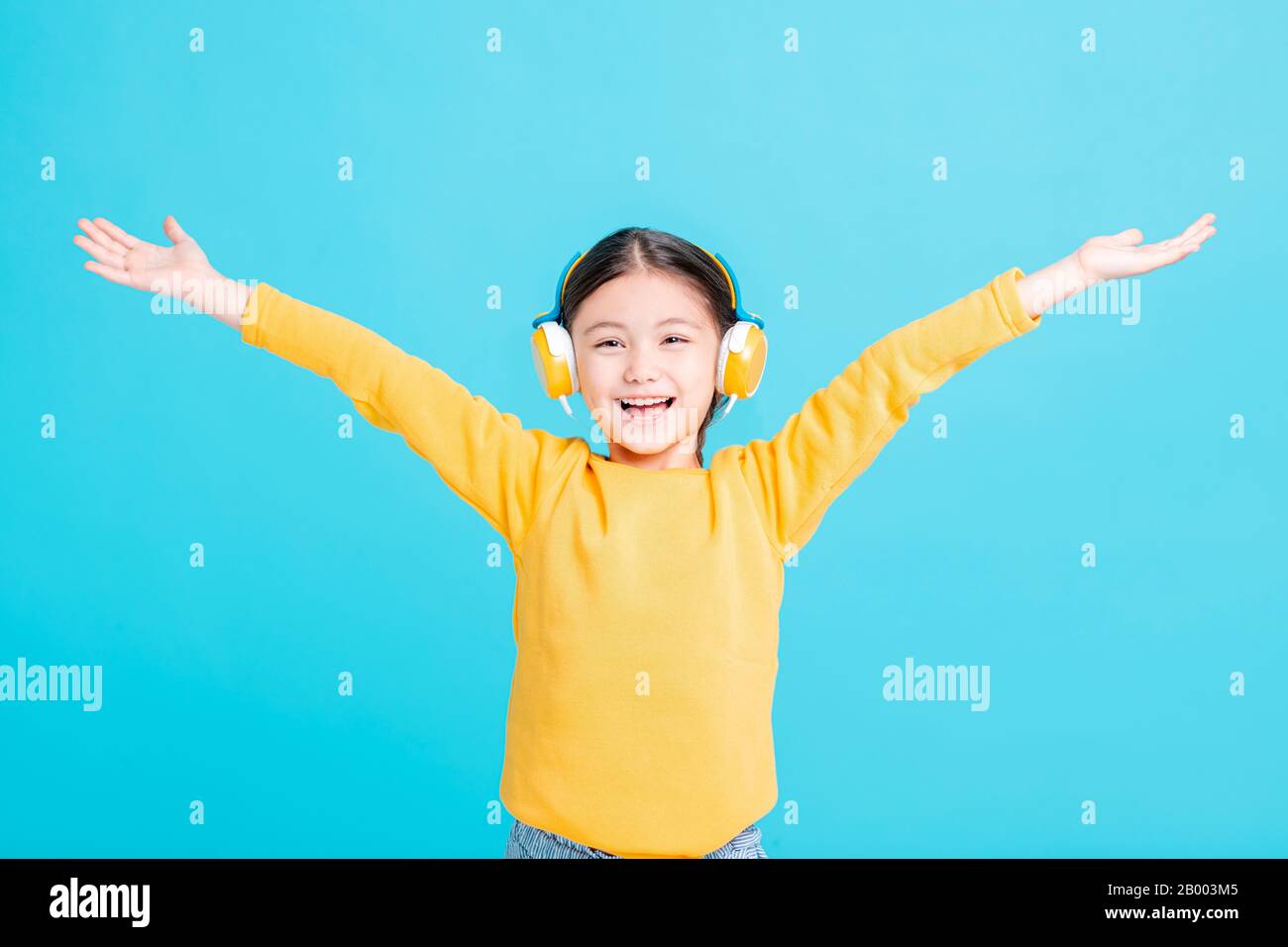La bambina felice ascolta la musica in cuffia Foto Stock