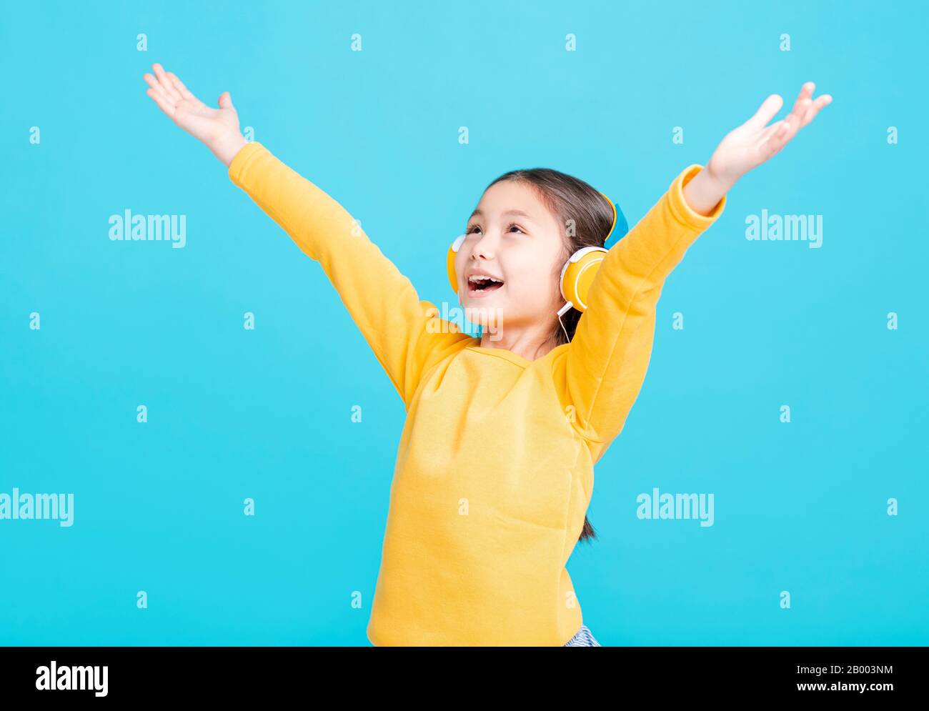 La bambina felice ascolta la musica in cuffia Foto Stock