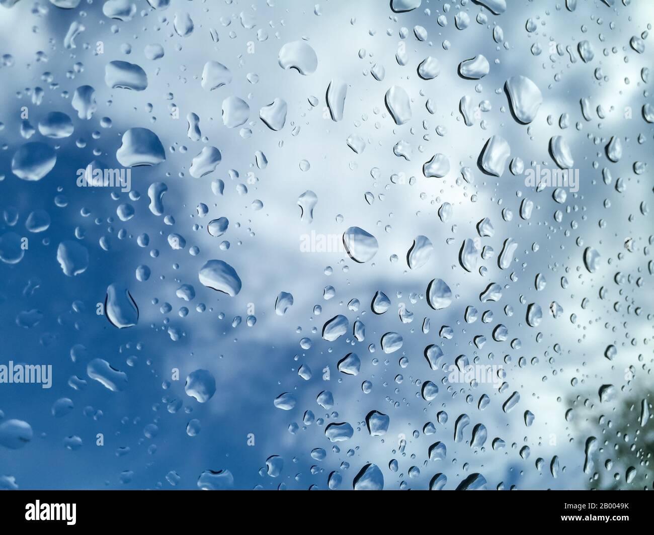 Sfondo dello schema di caduta dell'acqua su una superficie di vetro., Gocce D'Acqua sulla Superficie blu. Foto Stock