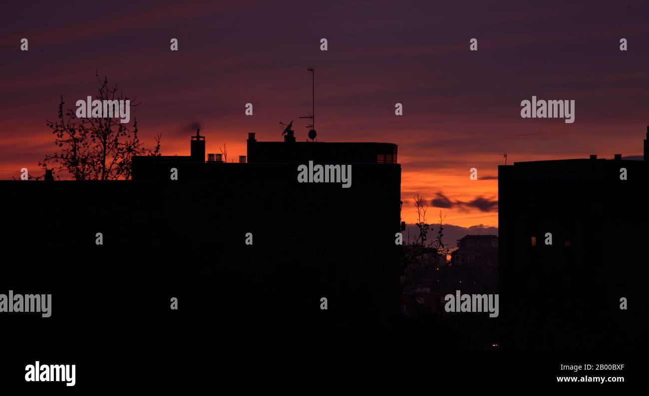 Spettacolare tramonto sulla città. Concetto di riscaldamento globale, silhouette Skyline Foto Stock