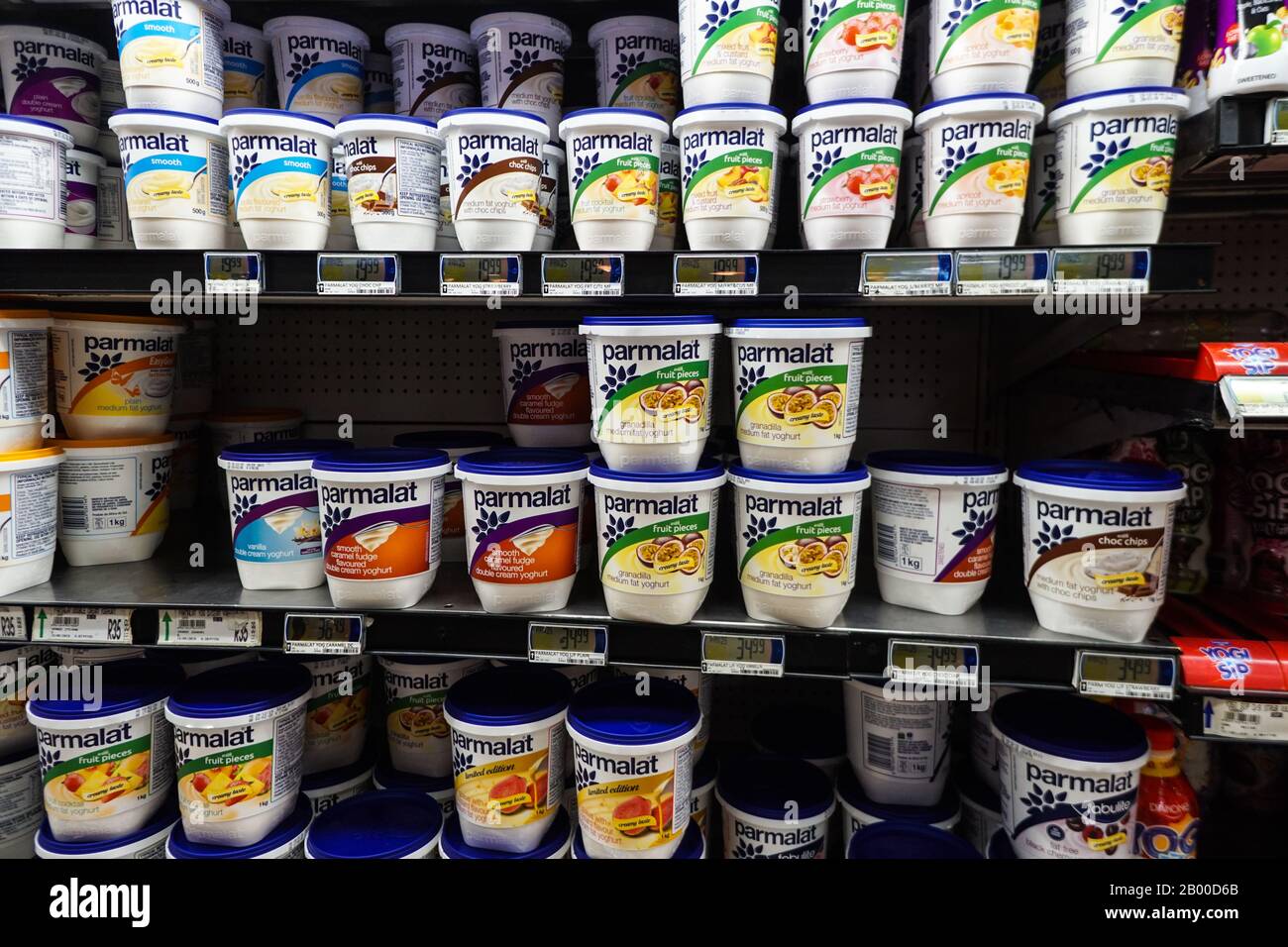Ripiani frigoriferi confezionati con vasche di plastica o contenitori di yogurt Parmalat in un supermercato o negozio in Sud Africa Foto Stock