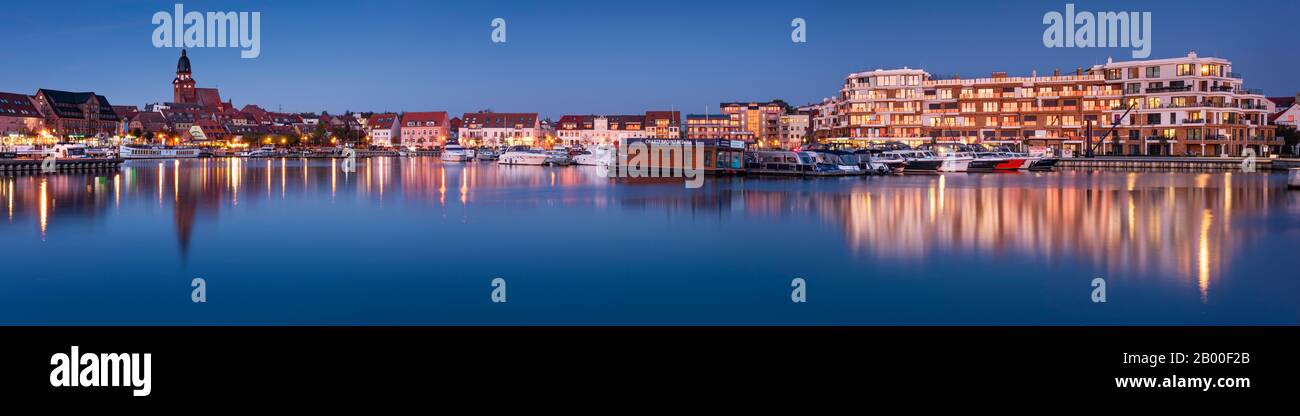 Panorama, porto cittadino con chiesa di S. Marien e moderno complesso alberghiero al crepuscolo, Waren an der Mueritz, Mecklenburg Lake District, Mecklenburg-Western Foto Stock