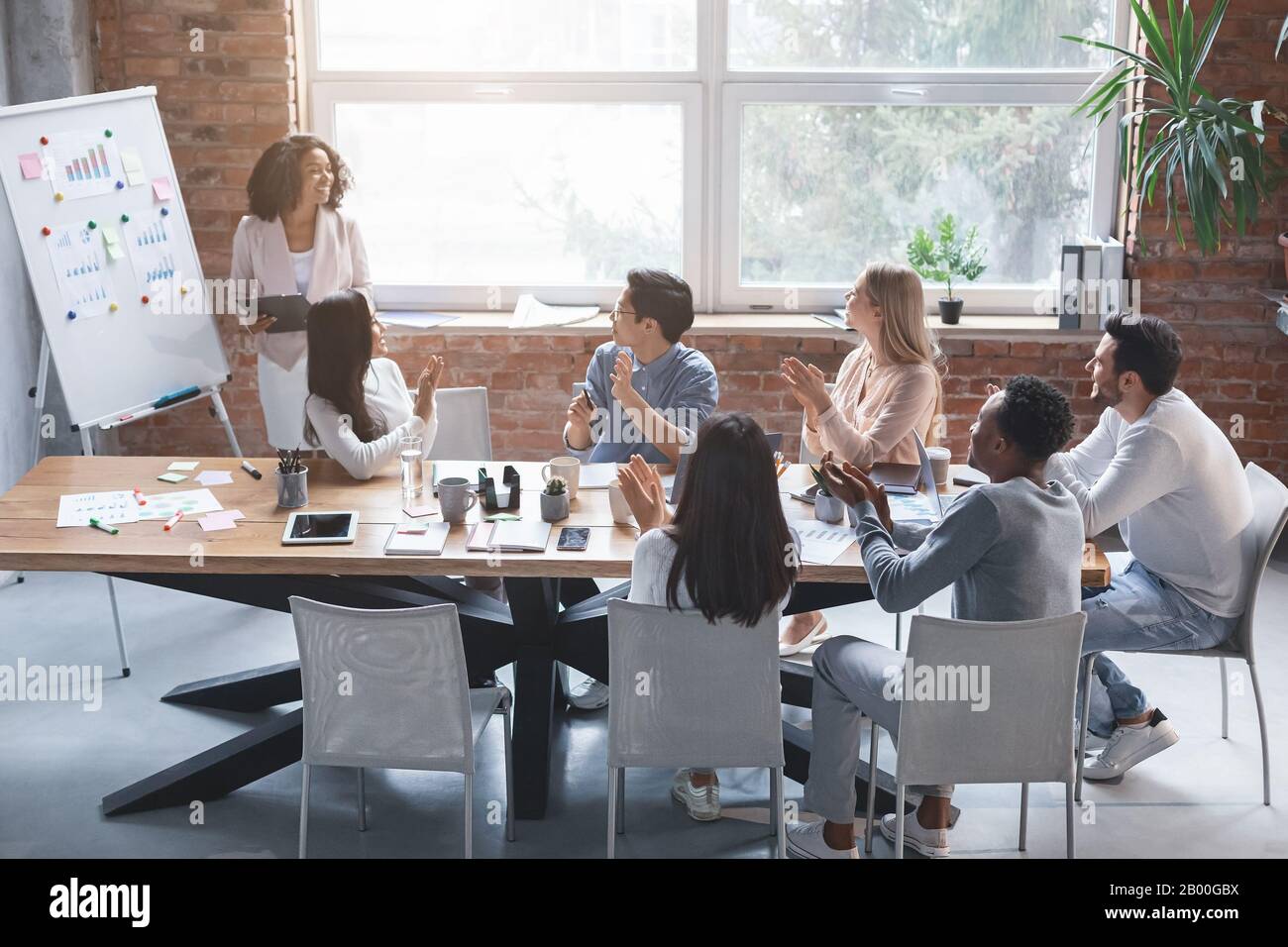 Signora creativa nera che parla davanti al team aziendale Foto Stock