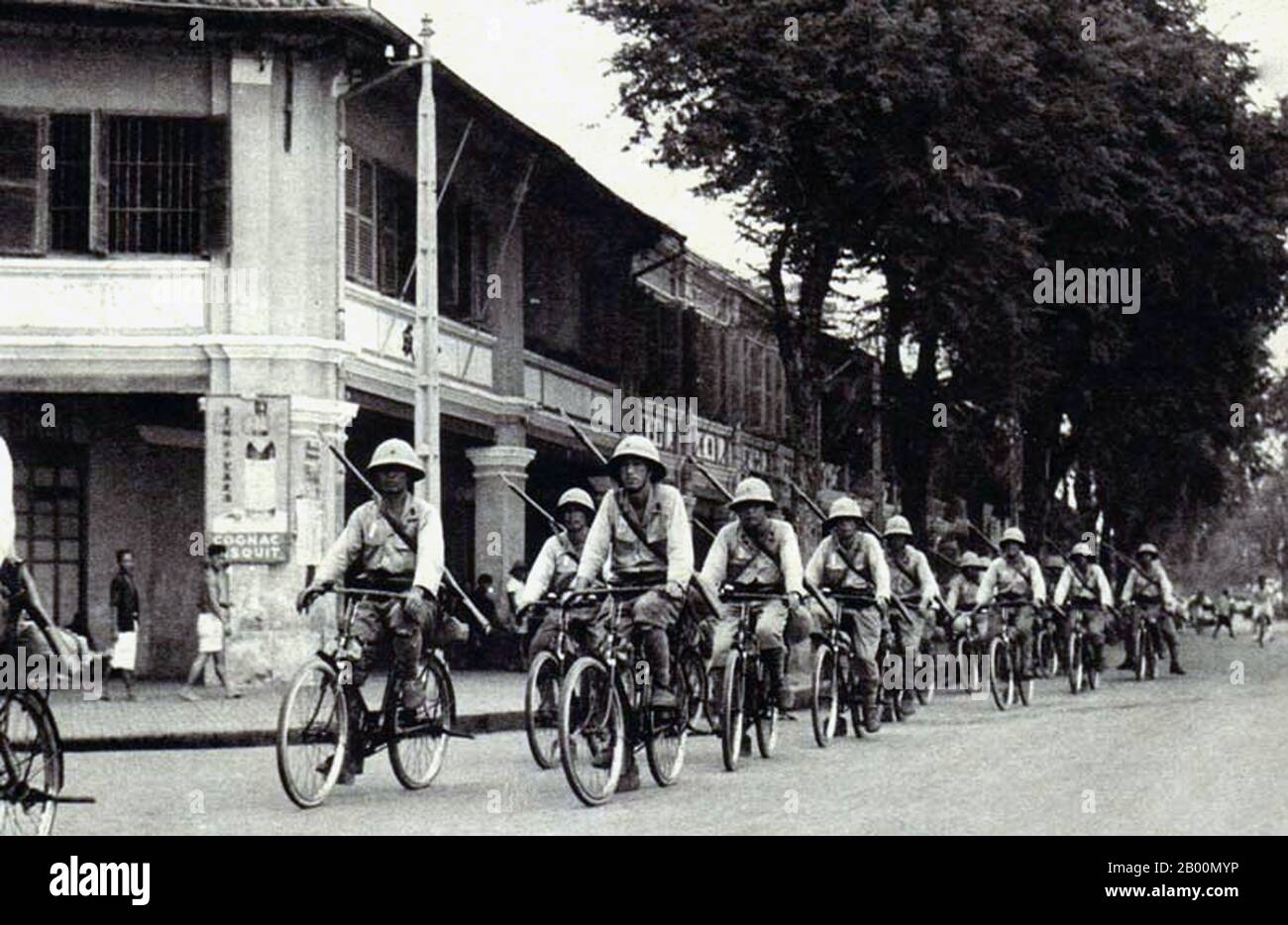 Vietnam: Truppe imperiali dell'esercito giapponese in bicicletta attraverso Saigon, c.. 1942. L'invasione giapponese dell'Indochina francese, nota anche come spedizione del Vietnam, fu una mossa dell'Impero del Giappone nel settembre 1940, durante la seconda guerra sino-giapponese, per impedire alla Cina di importare armi e combustibile attraverso l'Indochina francese, Attraverso la ferrovia sino-vietnamita dal porto di Haiphong attraverso Hanoi a Kunming in Yunnan. Il Giappone occupò l'Indochina settentrionale, che rafforzò il blocco della Cina, e rese superflua la continuazione della battaglia di Guangxi meridionale. Foto Stock