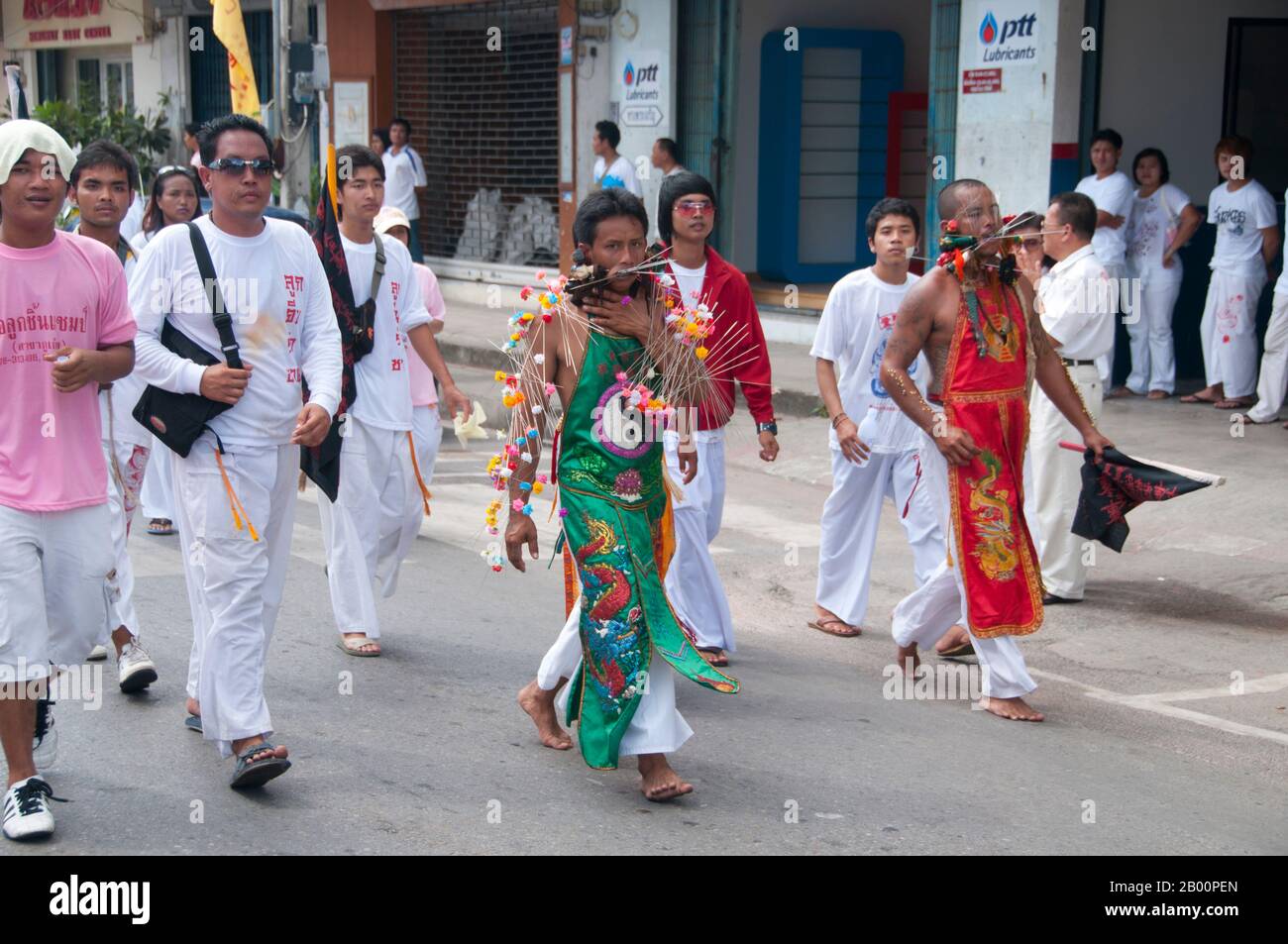 Thailandia: Il devoto o 'ma Song' partecipa a una processione attraverso la città di Phuket, Phuket Vegetarian Festival. Il Festival vegetariano è un festival religioso che si tiene ogni anno sull'isola di Phuket, nel sud della Thailandia. Attrae folle di spettatori a causa di molti degli insoliti rituali religiosi che vengono eseguiti. Molti devoti religiosi si schianteranno di spade, perforeranno le loro guance con oggetti taglienti e commetteranno altri atti dolorosi. Foto Stock