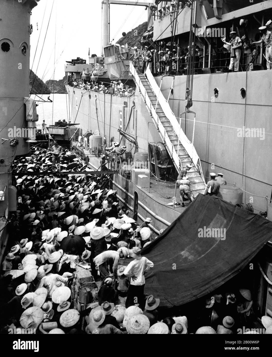 Vietnam: Rifugiati in fuga da Haiphong a bordo della USS Montague nel 1954 al momento del ritiro francese. Rifugiati del Vietnam. La USS Montague abbassa una scala sul lato per portare i rifugiati a bordo. Haiphong, agosto 1954. Immagine di dominio pubblico di H.S. Emathill. (US Navy). Foto Stock