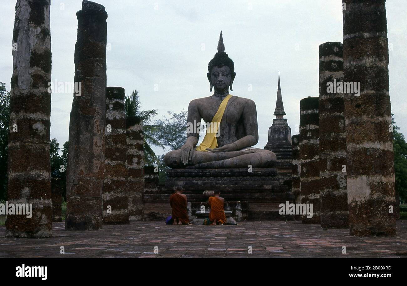 Thailandia: Monaci prostata prima di un Buddha, Wat Mahathat, Sukhothai Historical Park. Wat Mahathat fu fondata nel XIII secolo dal re Intharathit (c.. 1240-70) e ricostruito nel 14 ° secolo. Era il cuore spirituale del regno di Sukhothai. Sukhothai, che letteralmente significa "Alba della felicità", fu la capitale del regno di Sukhothai e fu fondata nel 1238. Fu la capitale dell'Impero Tailandese per circa 140 anni. Foto Stock