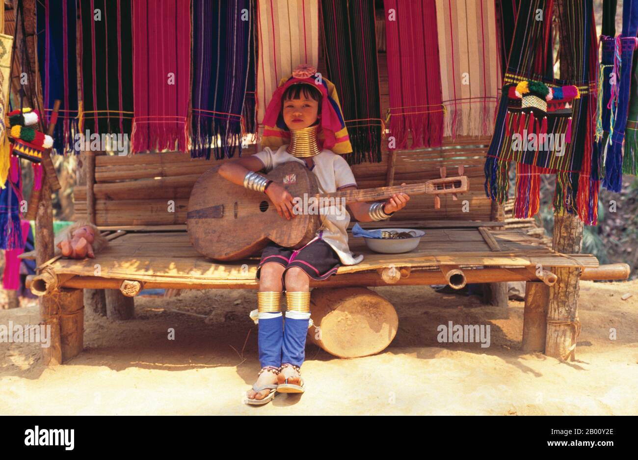 Thailandia: Padaung (Long Neck Karen) suonare una chitarra fatta in casa, villaggio vicino Mae Hong Son. I Padaung o Kayan Lahwi o Long Necked Karen sono un sottogruppo del Kayan, un misto di tribù dei Lawi, tribù dei Kayan e molte altre tribù. I Kayan sono un sottogruppo del popolo Karen Rosso (Karenni), una minoranza etnica tibetana-burman della Birmania (Myanmar). Foto Stock