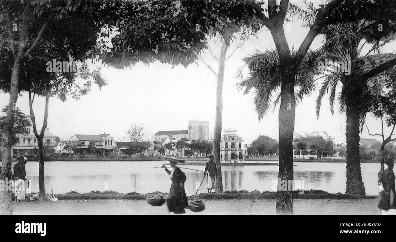 Vietnam: Lago Hoan Kiem, Hanoi (inizio 20 ° secolo). Il lago Hoan Kiem, che significa "Lago della Spada restituita", si trova nel centro storico di Hanoi ed è oggi uno dei luoghi più panoramici e famosi della capitale vietnamita. Secondo la leggenda, il lago prende il nome da una spada magica appartenente all'imperatore le Loi, che lo ha portato la vittoria nella sua rivolta contro la dinastia cinese Ming. Un ponte in legno dipinto di rosso chiamato Huc Bridge collega l'isola di Jade alla riva del lago. Il Tempio di Ngoc Son (Tempio di Jade Mountain) si trova sull'isola. Foto Stock