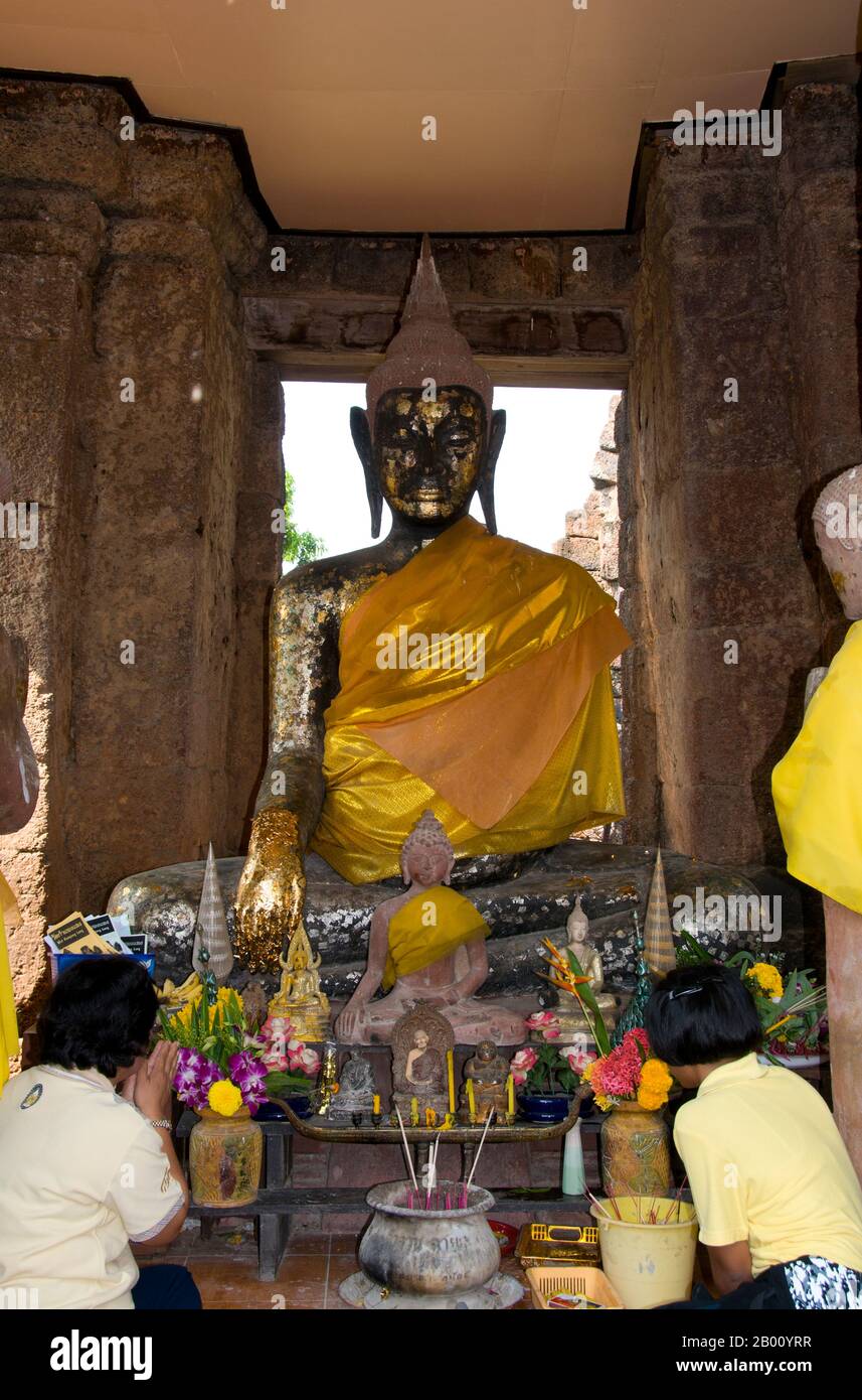 Thailandia: I fedeli prostrano davanti a un Buddha in uno dei santuari Khmer a Wat Kamphaeng Laeng, Phetchaburi. Wat Kamphaeng Laeng era originariamente un luogo di culto Khmer Hindu del XII secolo, che successivamente divenne un tempio buddista. Phetchaburi probabilmente segnò anche l'estensione più meridionale dell'Impero Khmer. Foto Stock