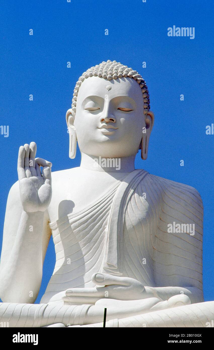 Sri Lanka: Buddha gigante seduto ad Ambasshala Dagoba, Mihintale. Mihintale è una vetta montana nei pressi di Anuradhapura che si ritiene sia il luogo di un incontro tra il monaco buddista Mahinda e il re Devanampiyatissa che ha inaugurato la presenza del buddismo nello Sri Lanka. È ora un luogo di pellegrinaggio, e il sito di diversi monumenti religiosi e strutture abbandonate. Foto Stock