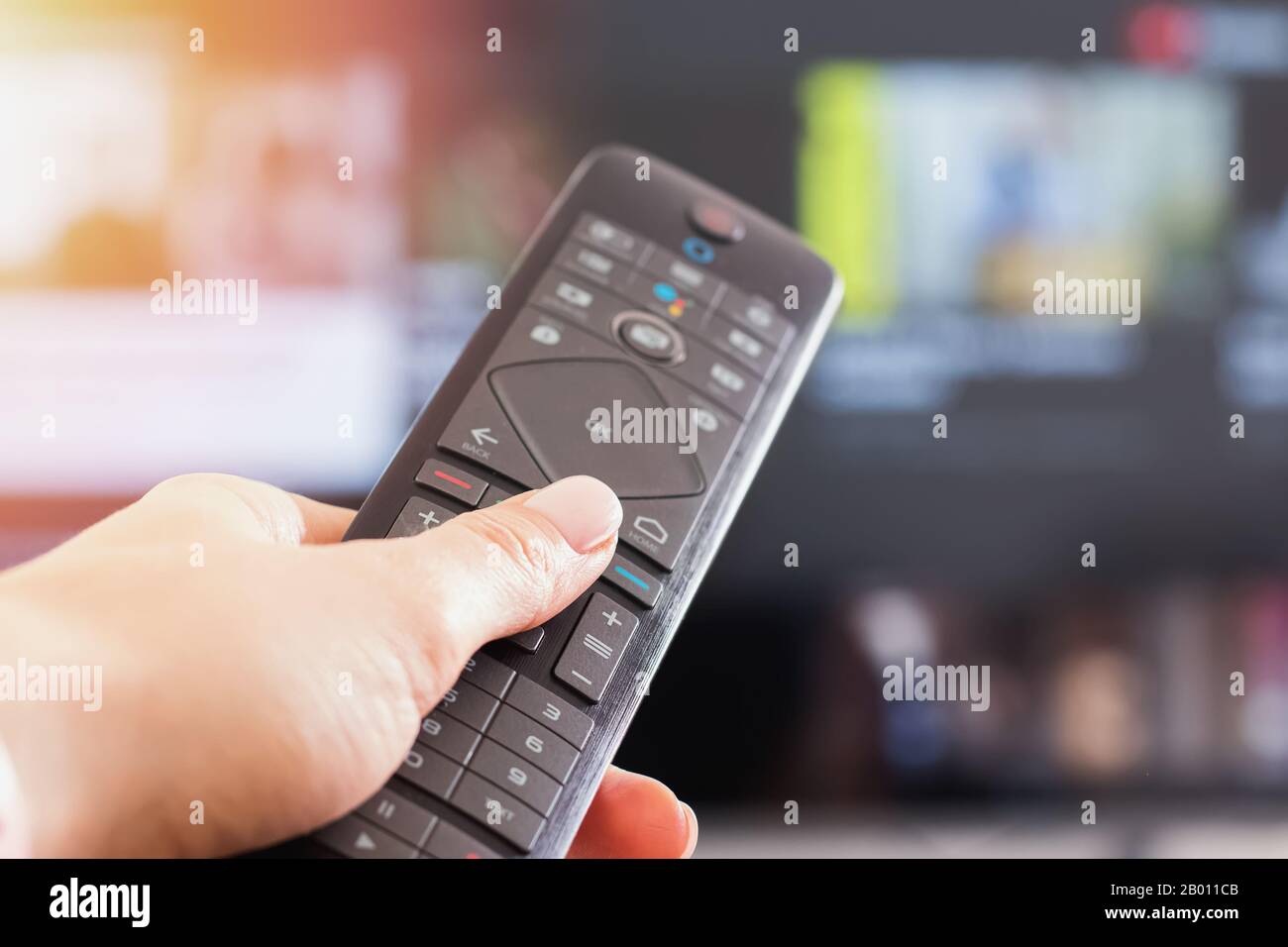 Primo piano del telecomando per donna davanti alla TV, Foto Stock