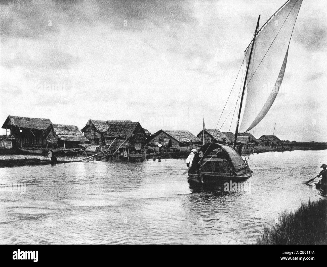 Thailandia: Una chiatta di riso naviga oltre un villaggio sul canale Rangsit, c. 1900. Klong Rangsit, o Rangsit Canal, è stato il primo progetto di irrigazione in Siam ed è situato nella parte orientale della valle di Chao Phraya, nella Thailandia centrale. La costruzione del canale fu ordinata dal re Chulalongkorn (Rama V) nel 1890, e fu chiamata in onore di suo figlio, Rangsit, Principe di Chainat. Foto Stock