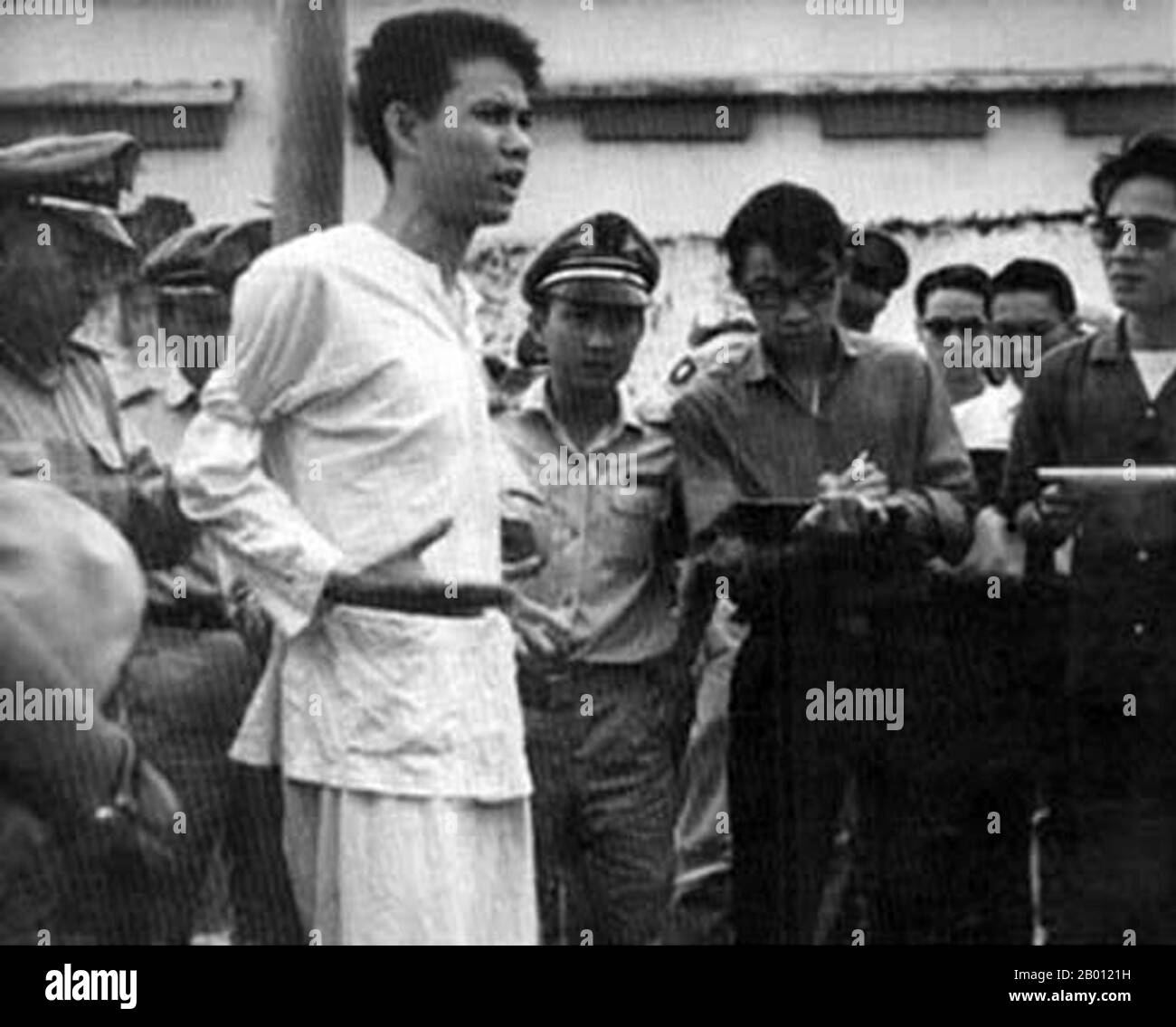 Vietnam: Nguyen Van Troi (1947-1964), NLF Fighter, in procinto di essere giustiziato, Saigon, 15 ottobre 1964. Nguyen Van Troi (1947 – 15 ottobre 1964) è stato un . Divenne noto dopo essere stato catturato dal Vietnam del Sud quando tentò di assassinare il Segretario della Difesa degli Stati Uniti Robert McNamara e il futuro ambasciatore Henry Cabot Lodge, Jr. Che stavano visitando il Vietnam del Sud nel maggio 1963. Fu giustiziato da una squadra di 17 anni. La sua esecuzione è stata filmata, e lui è rimasto infefatto fino alla fine. Le sue ultime parole come i colpi sono stati sparati erano 'Long Live Vietnam!'. Foto Stock