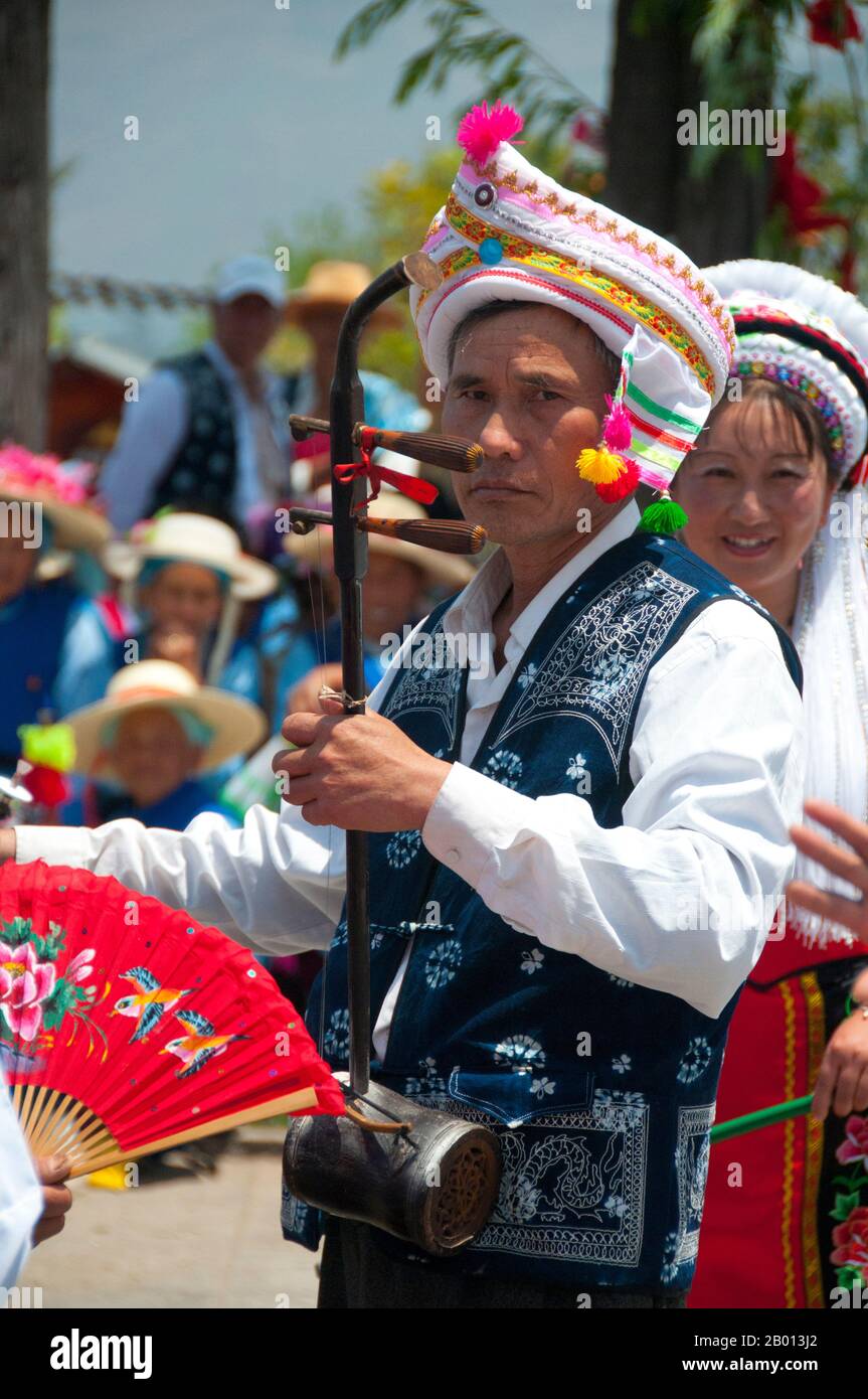 Cina: Un uomo Bai porta un erhu (violino cinese), musica Bai e festival di danza a Santa si (tre Pagodas), Dali, Yunnan. I Bai o Baip sono uno dei 56 gruppi etnici ufficialmente riconosciuti dalla Repubblica popolare Cinese. I Bai vivono soprattutto nelle province di Yunnan (zona di Dali), e nelle vicine province di Guizhou (zona di Bijie) e Hunan (zona di Sangzhi). Dalì è l'antica capitale sia del regno di Bai Nanzhao, che fiorì nella zona durante l'VIII e IX secolo, sia del regno di Dali, che regnò dal 937 al 1253. Foto Stock