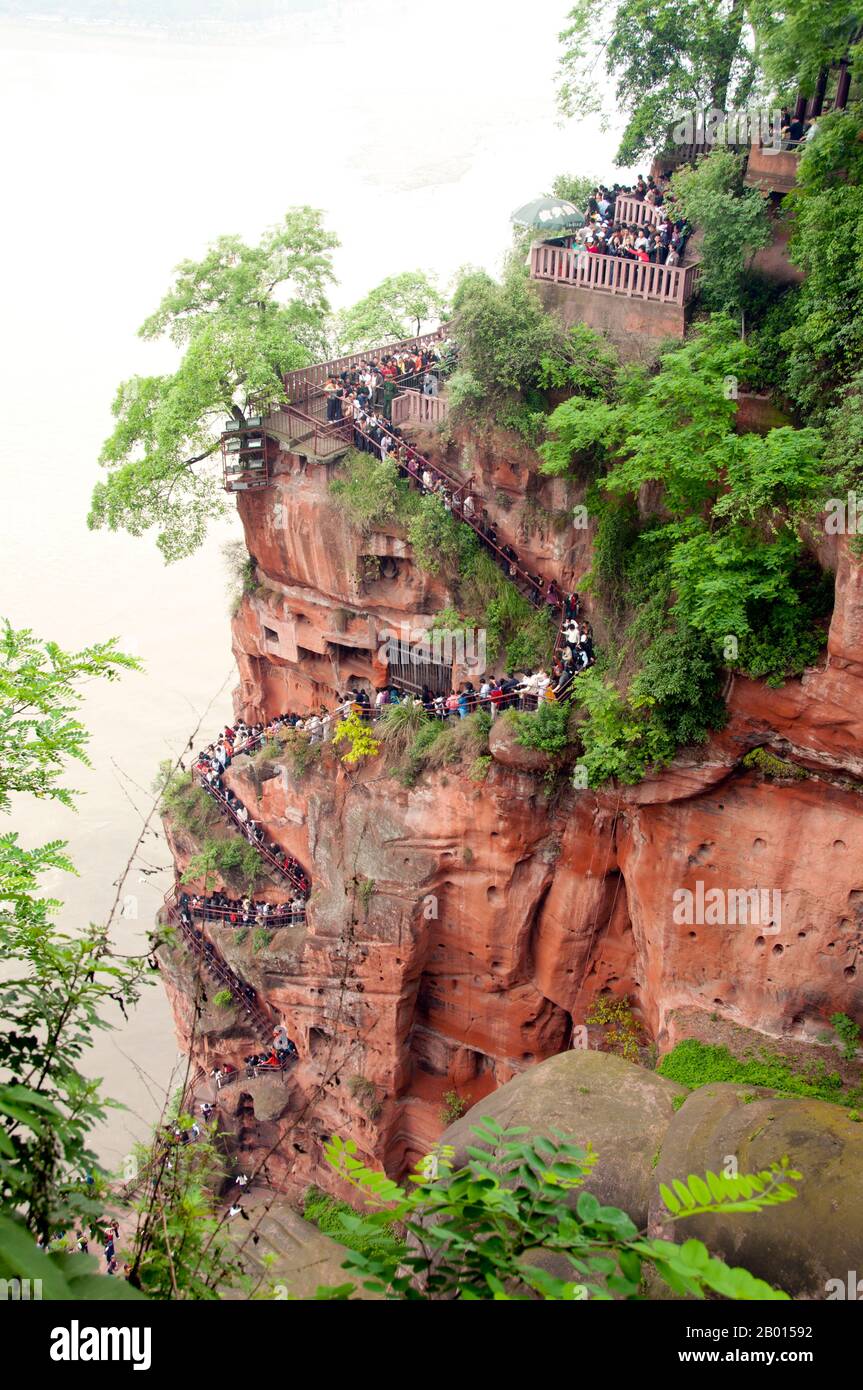 Cina: Scala piena di visitatori in attesa di ottenere una vista di Dafo (Buddha gigante) dai suoi piedi, Leshan, provincia Sichuan. Il Buddha gigante di Leshan (Lèshān Dàfó) fu costruito durante la dinastia Tang (618–907 CE). È scolpito da una scogliera che si trova alla confluenza dei fiumi Minjiang, Dadu e Qingyi nella parte meridionale della provincia di Sichuan in Cina, vicino alla città di Leshan. La scultura in pietra si affaccia sul monte Emei, con i fiumi che scorrono sotto i suoi piedi. È il Buddha in pietra intagliato più grande del mondo e al momento della sua costruzione era la statua più alta del mondo. Foto Stock