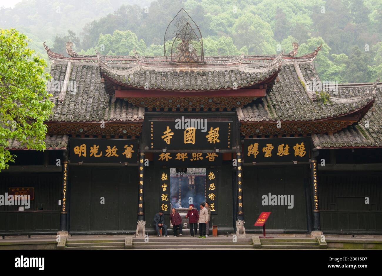 Cina: Ingresso a Baoguo si (Tempio della nazione dichiarante), ai piedi di Emeishan (Monte Emei), provincia di Sichuan. Baoguo si (Tempio della Nazione Declare), ai piedi del Monte Emei, fu costruito per la prima volta nel XVI secolo durante la Dinastia Ming (1368-1644). A 3,099 metri (10,167 piedi), Mt. Emei è la più alta delle quattro Sacre montagne buddiste della Cina. Il patrono bodhisattva di Emei è Samantabhadra, conosciuto in cinese come Puxian. Fonti del XVI e XVII secolo alludono alla pratica delle arti marziali nei monasteri del Monte Emei. Foto Stock