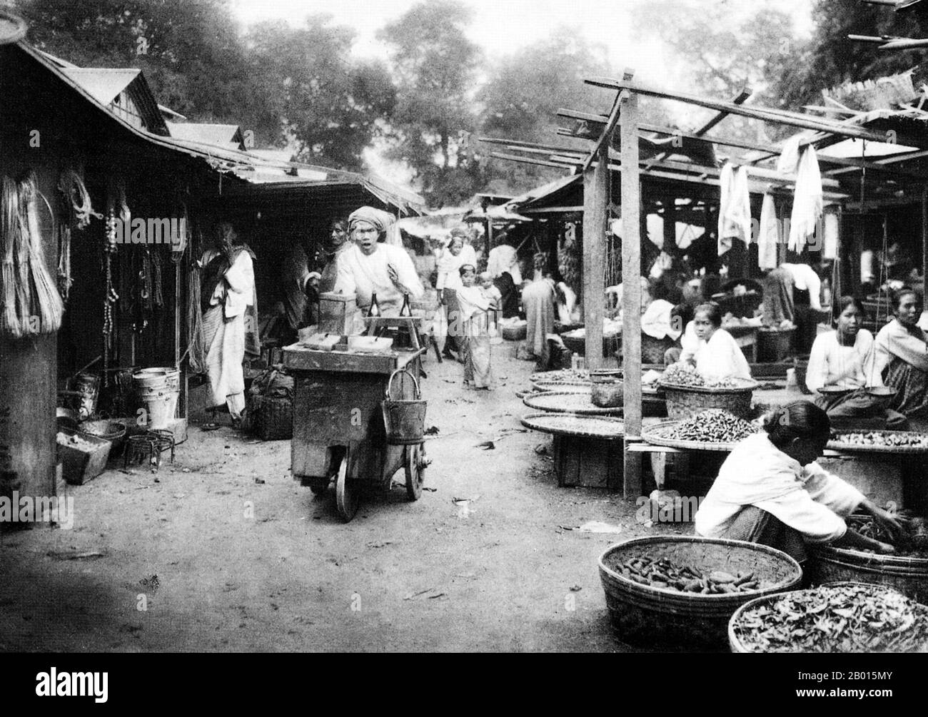 Birmania/Myanmar: Un mercato a Sagaing, nell'alta Birmania, negli anni '20. Sagaing è la capitale della regione di Sagaing (ex divisione Sagaing) in Birmania, conosciuta anche come Myanmar. Situato sul fiume Irrawaddy (Ayeyarwady), a 20 km a sud-ovest di Mandalay, Sagaing con numerosi monasteri buddisti è un importante centro religioso e monastico. Le pagode e i monasteri affollano le colline lungo la cresta che corre parallela al fiume. La pagoda centrale, ben presto U Ponya Shin Pagoda, è collegata da una serie di scale coperte che corrono fino alla collina di 240 m. Foto Stock