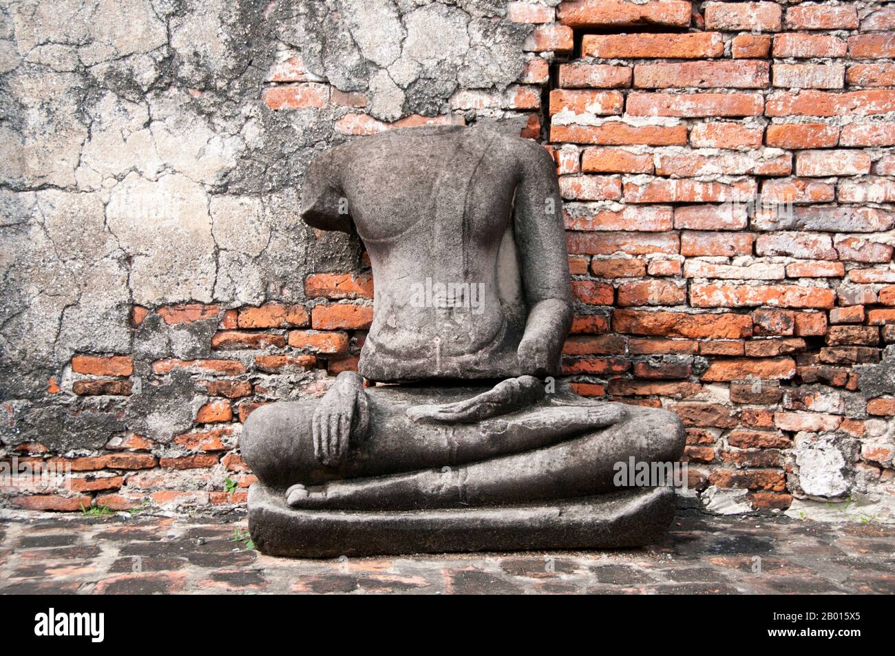 Thailandia: Buddha senza testa, Wat Phra Mahathat, Ayutthaya Historical Park. Wat Phra Mahathat fu costruito durante il regno di Borommaracha i (Boromma Rachathirat i) o Khun Luang Pa Ngua (1370-1388), che era il terzo re del regno di Ayutthaya. Ayutthaya (Ayudhya) era un regno siamese che esisteva dal 1351 al 1767. Ayutthaya era amichevole verso i commercianti stranieri, compreso il cinese, vietnamita (Annamese), indiani, giapponesi e persiani, E poi i portoghesi, spagnoli, olandesi e francesi, permettendo loro di creare villaggi fuori dalle mura della città. Foto Stock