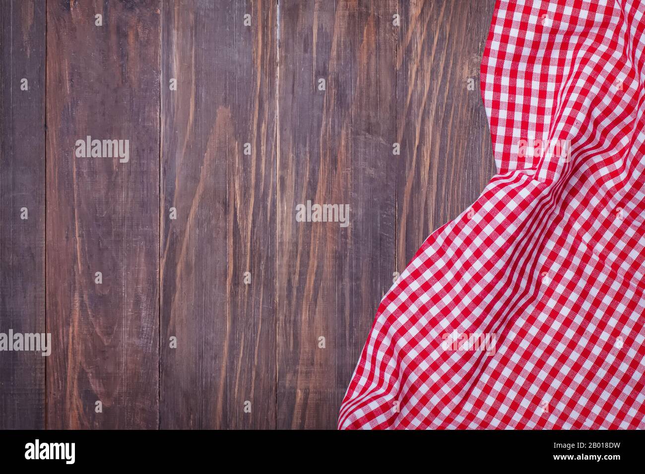 Tovagliolo rosso a scacchi su un tavolo rustico in legno con spazio copia per il posizionamento del testo o del prodotto. Foto Stock